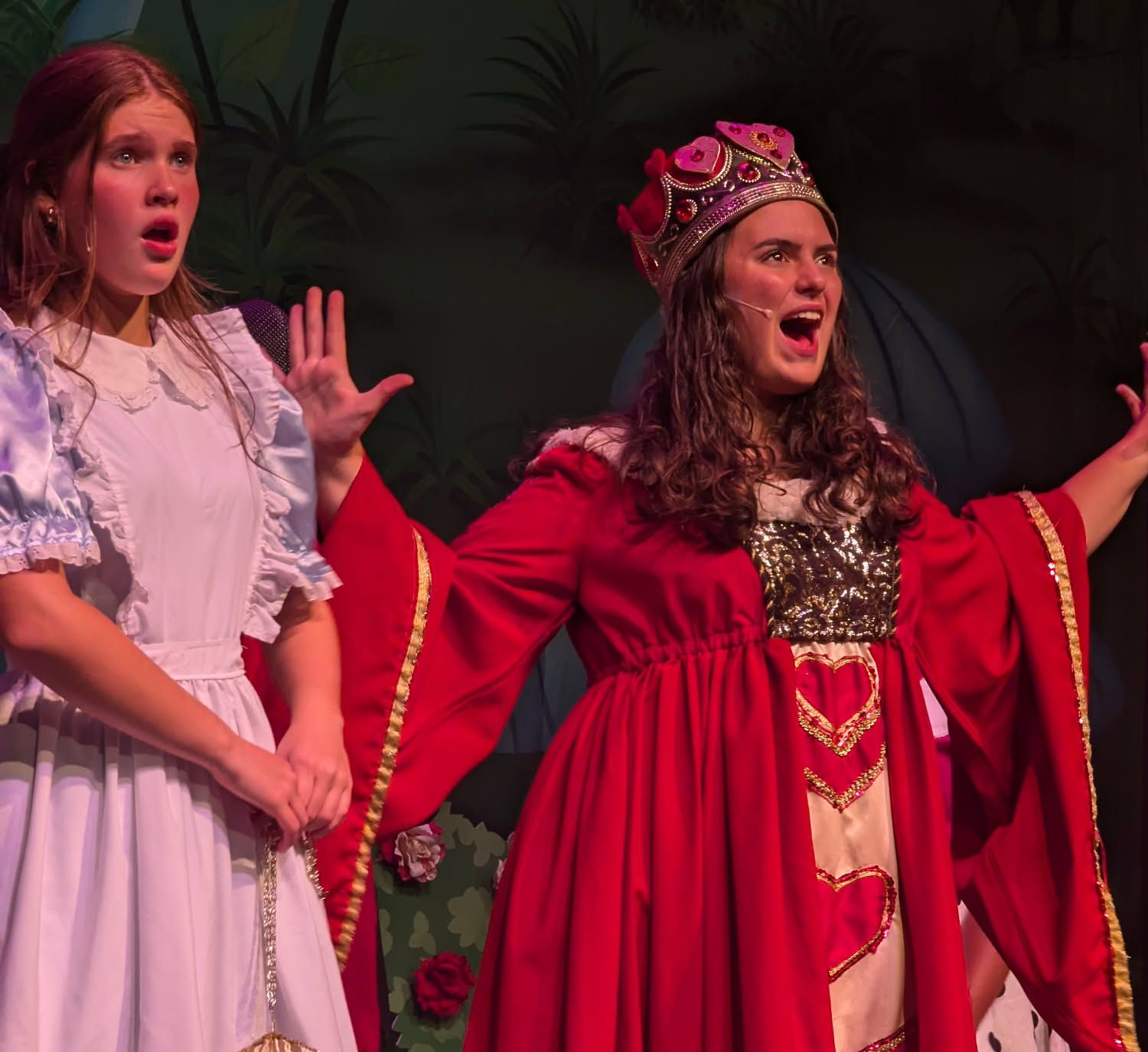 Ariel from The Little Mermaid musical, singing. Red hair, shell bra, green tail, reaching upward.