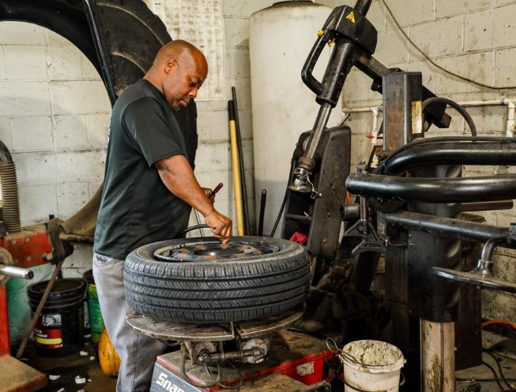 a man is working on a tire on a snap on machine