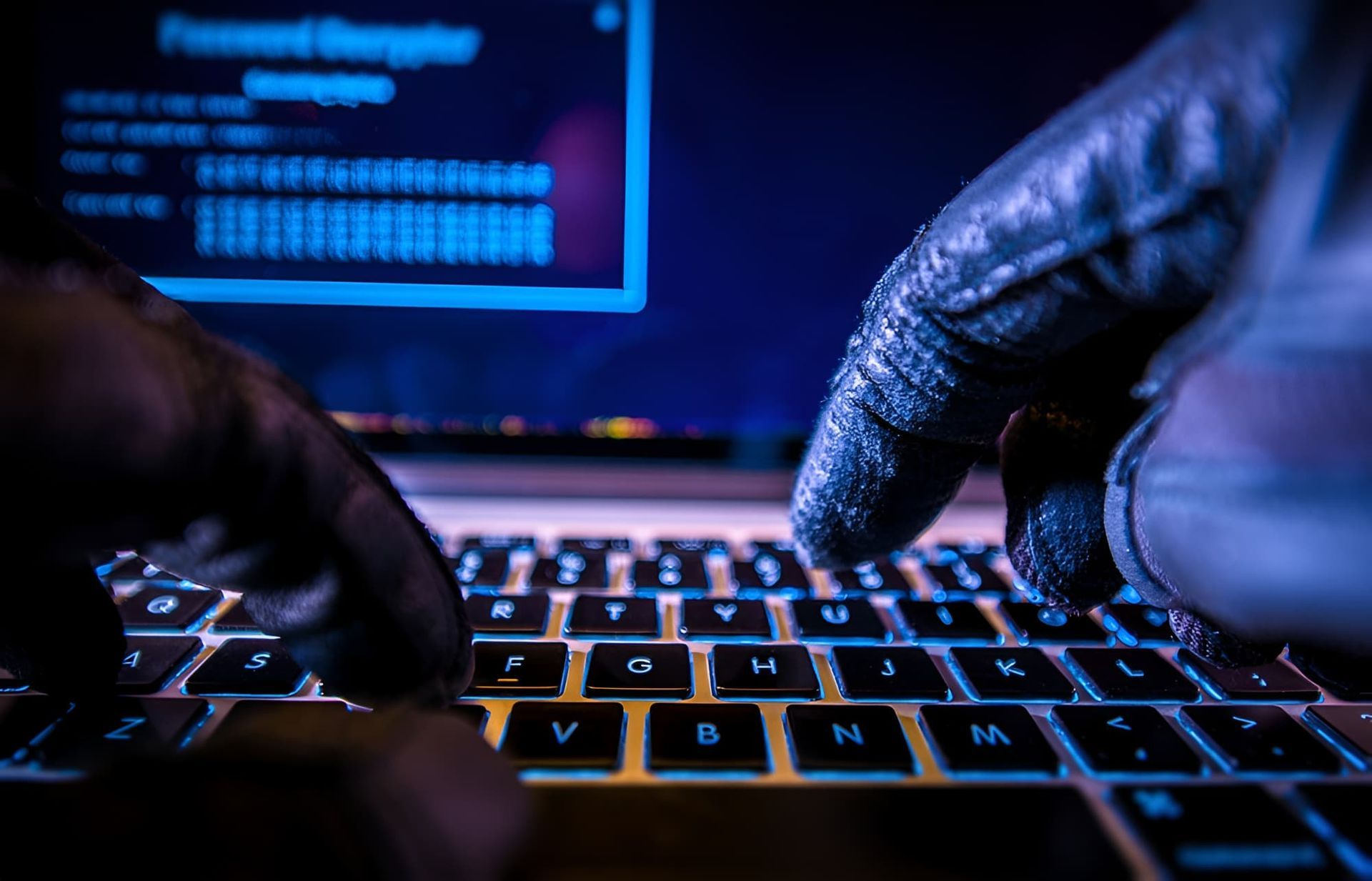 A Person Wearing Gloves Is Typing On A Laptop Computer — Cairns Criminal Lawyers In Redlynch, QLD
