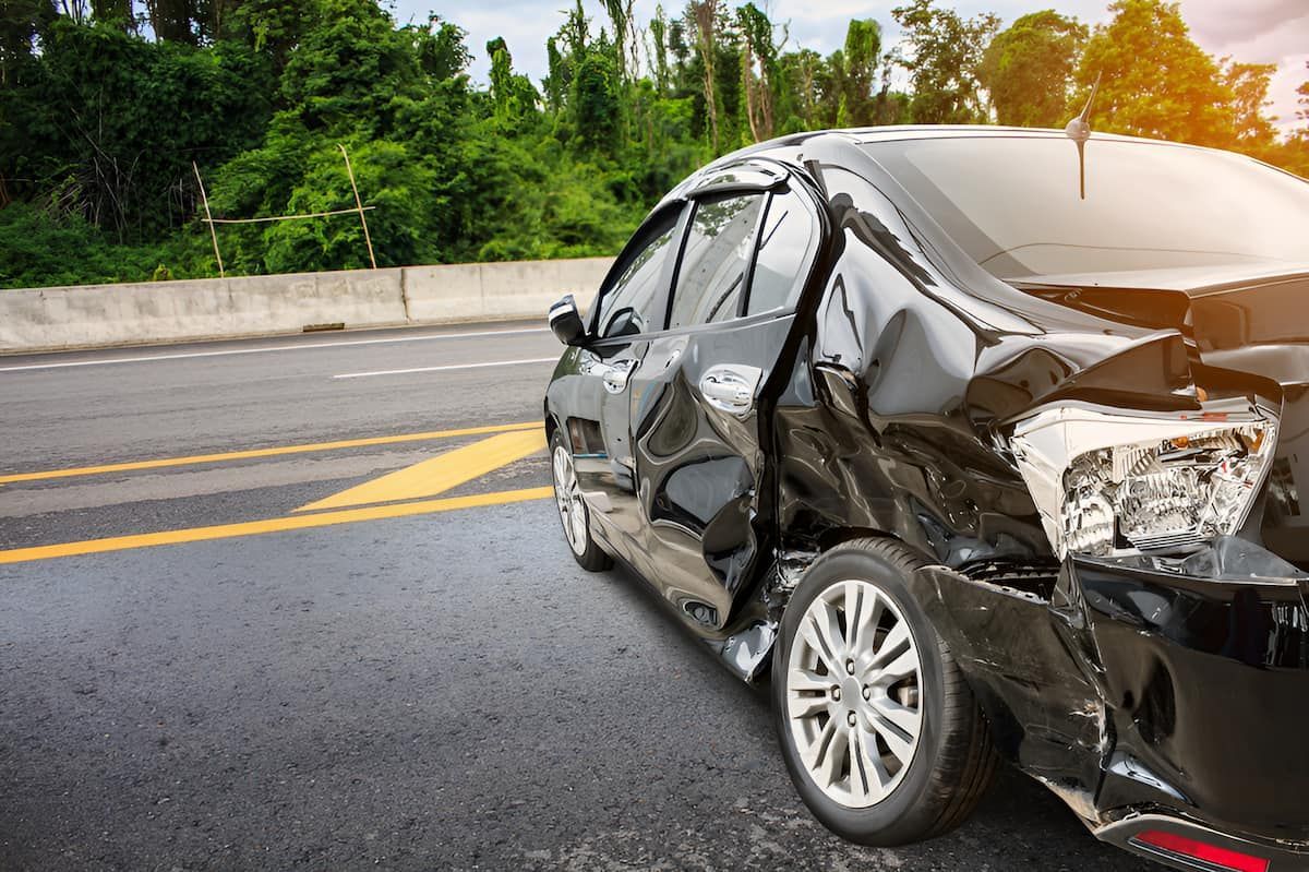 A Black Car Has Been Damaged In A Car Accident On The Side Of The Road — Cairns Criminal Lawyers In Cairns City, QLD
