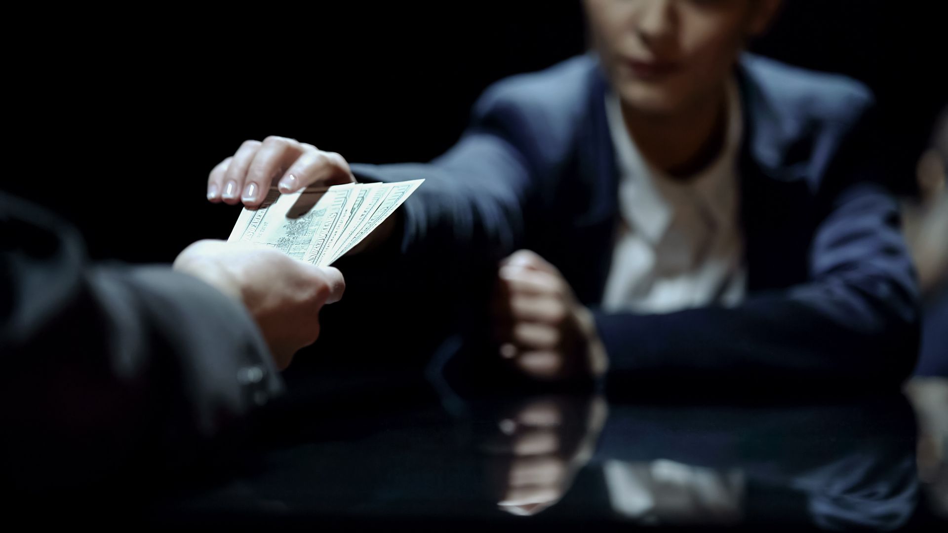 A Man is Handing a Woman a Piece of Money — Cairns Criminal Lawyers In Cairns City, QLD