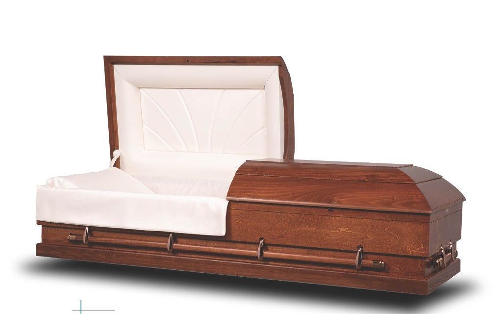 Wooden casket with white satin interior and a white pillow lid, shown open on a white background