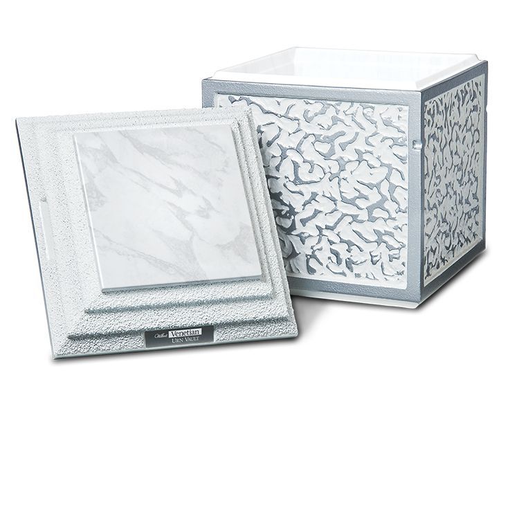 White decorative urn with a matching lid leaning beside it