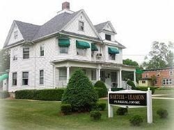 Bartel-Kimmons Funeral Home, white house with green awnings and sign on a grassy lawn.