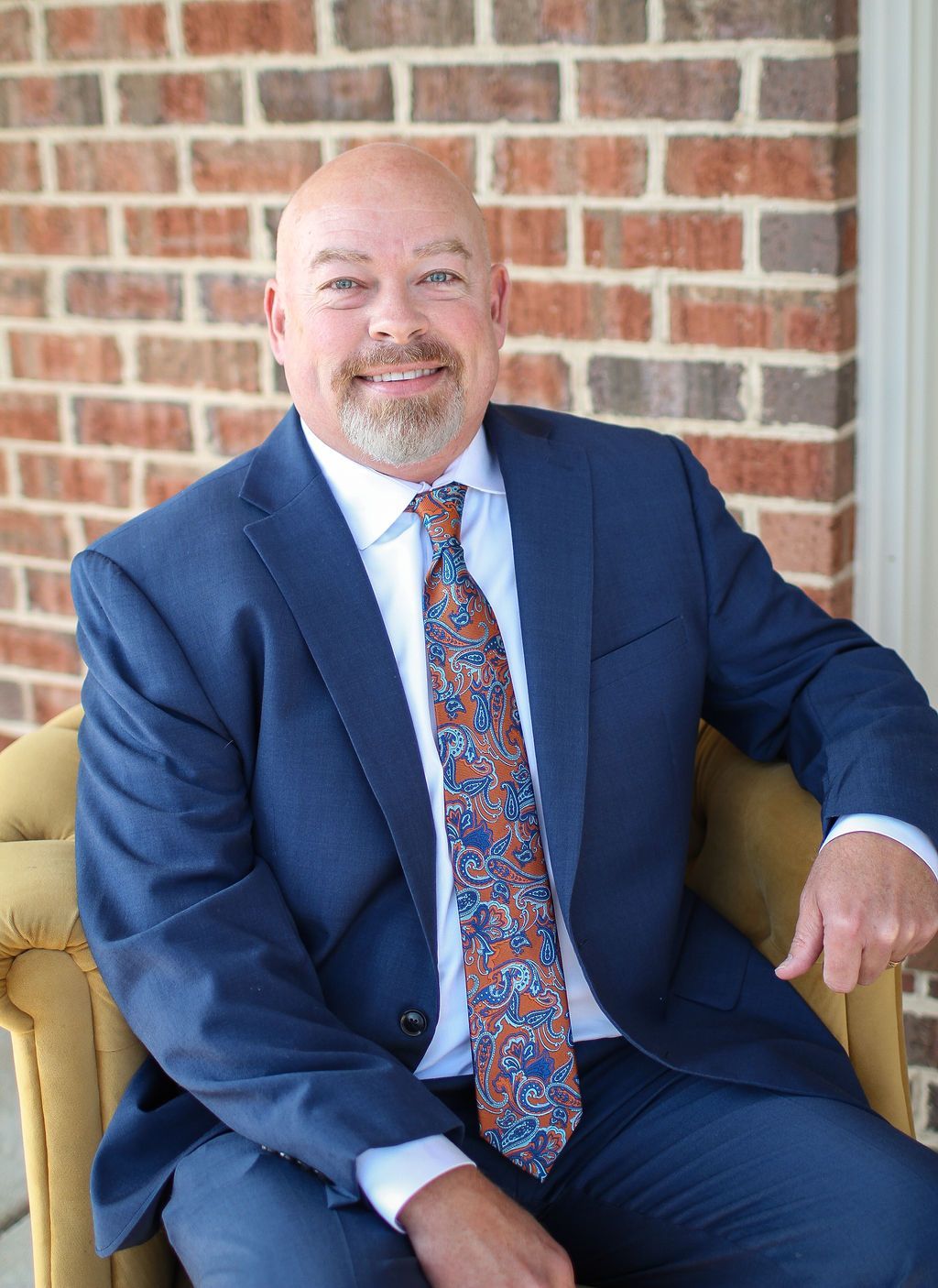 A man in a suit and white shirt is smiling for the camera.