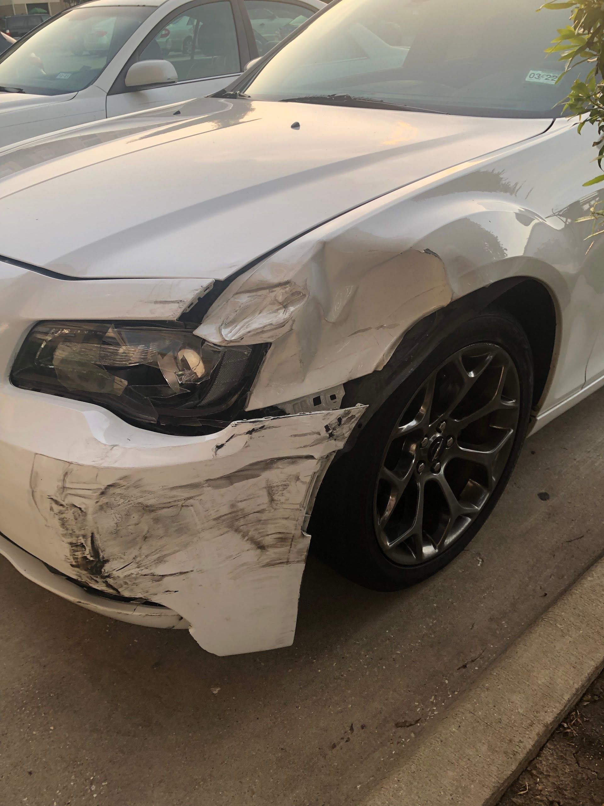 White car with front-end damage; crumpled fender, bumper, and headlight. | Meyerland Service Station