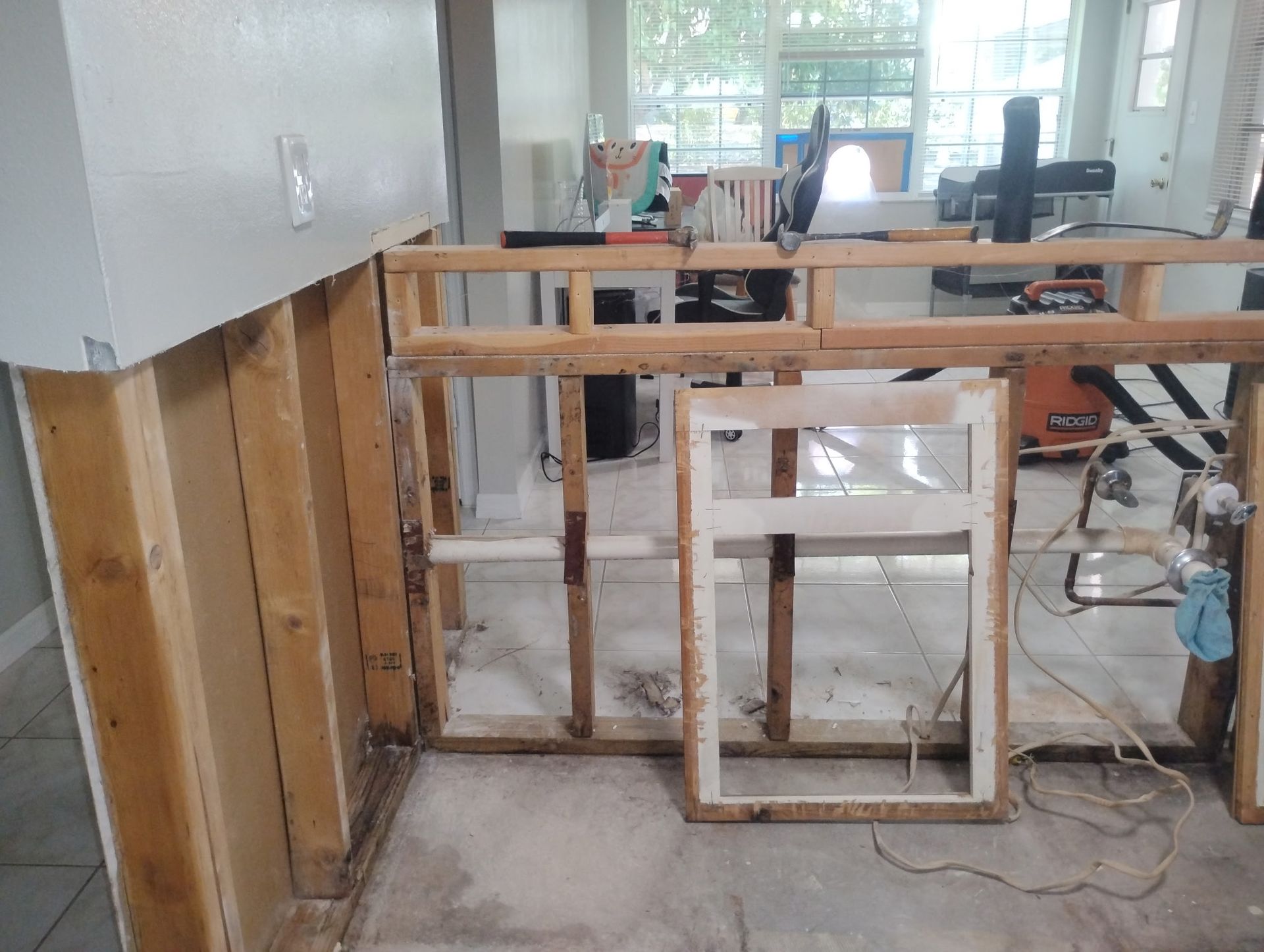 A wooden frame is being built in a room with a window.