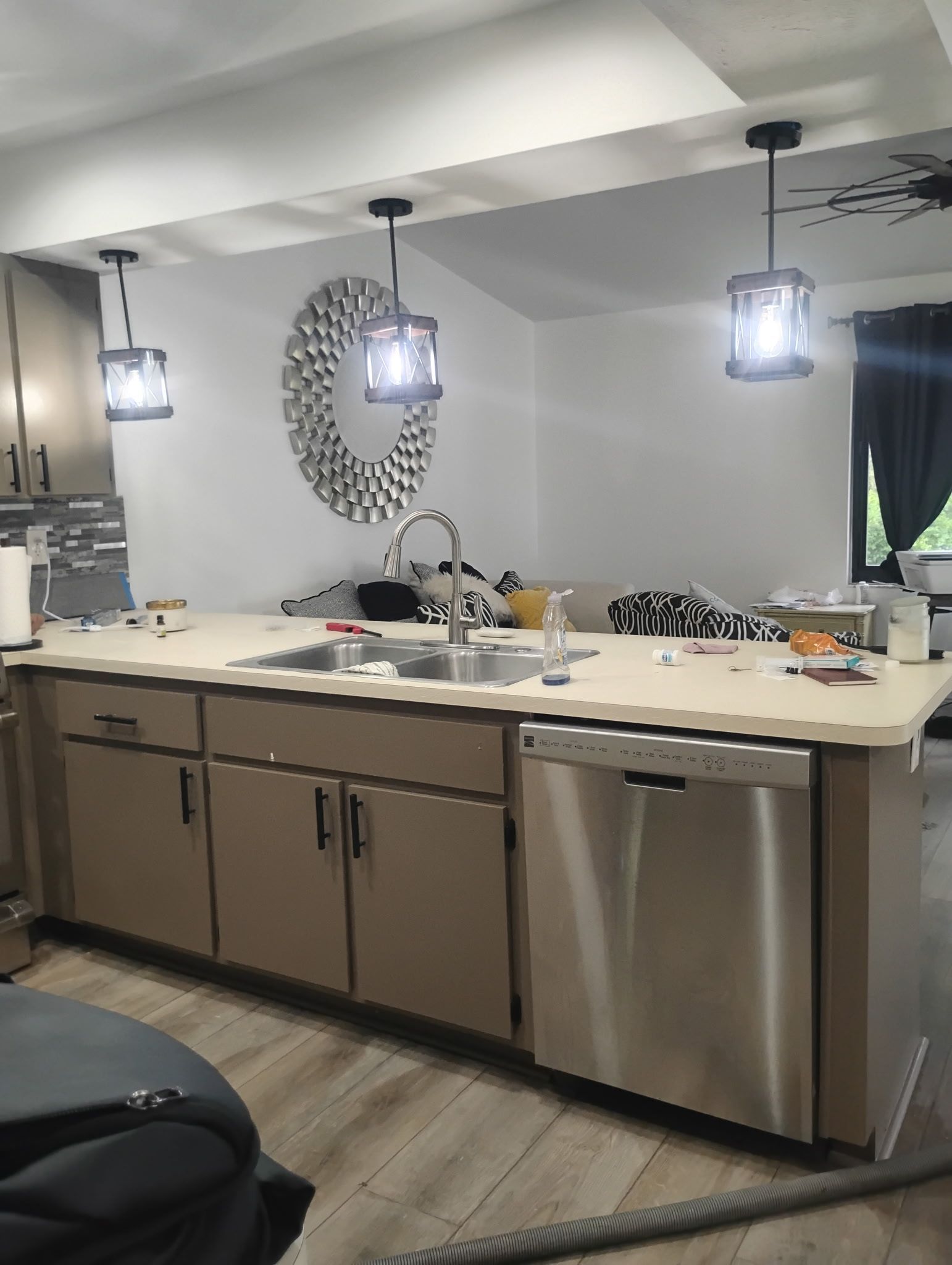 Kitchen with island, stainless steel appliances, pendant lights, and decorative mirror.