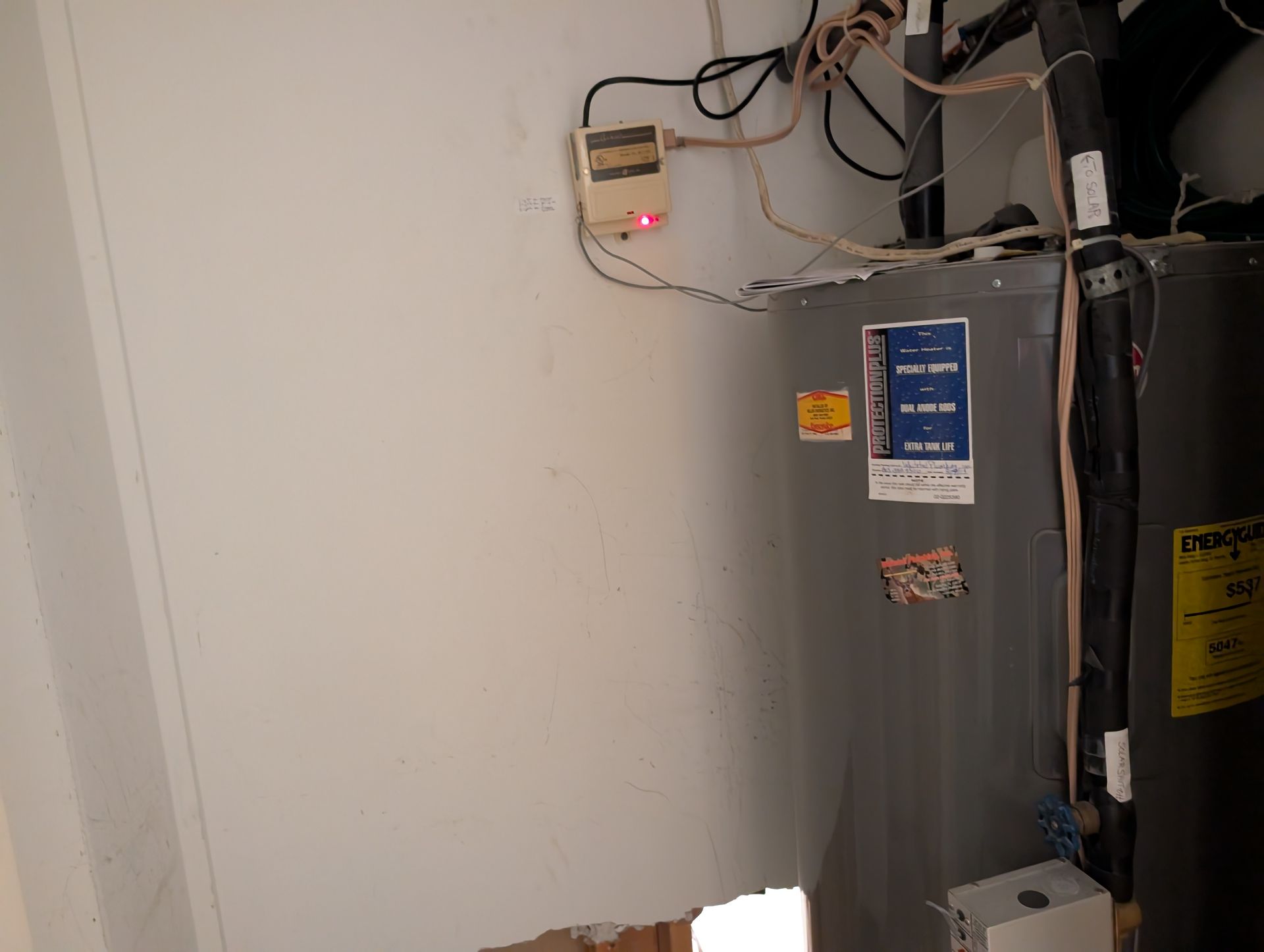 Water heater and electrical components near a wall.