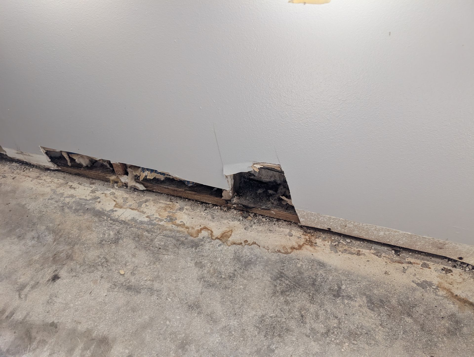 Damaged ceiling corner with crumbling wood and staining.