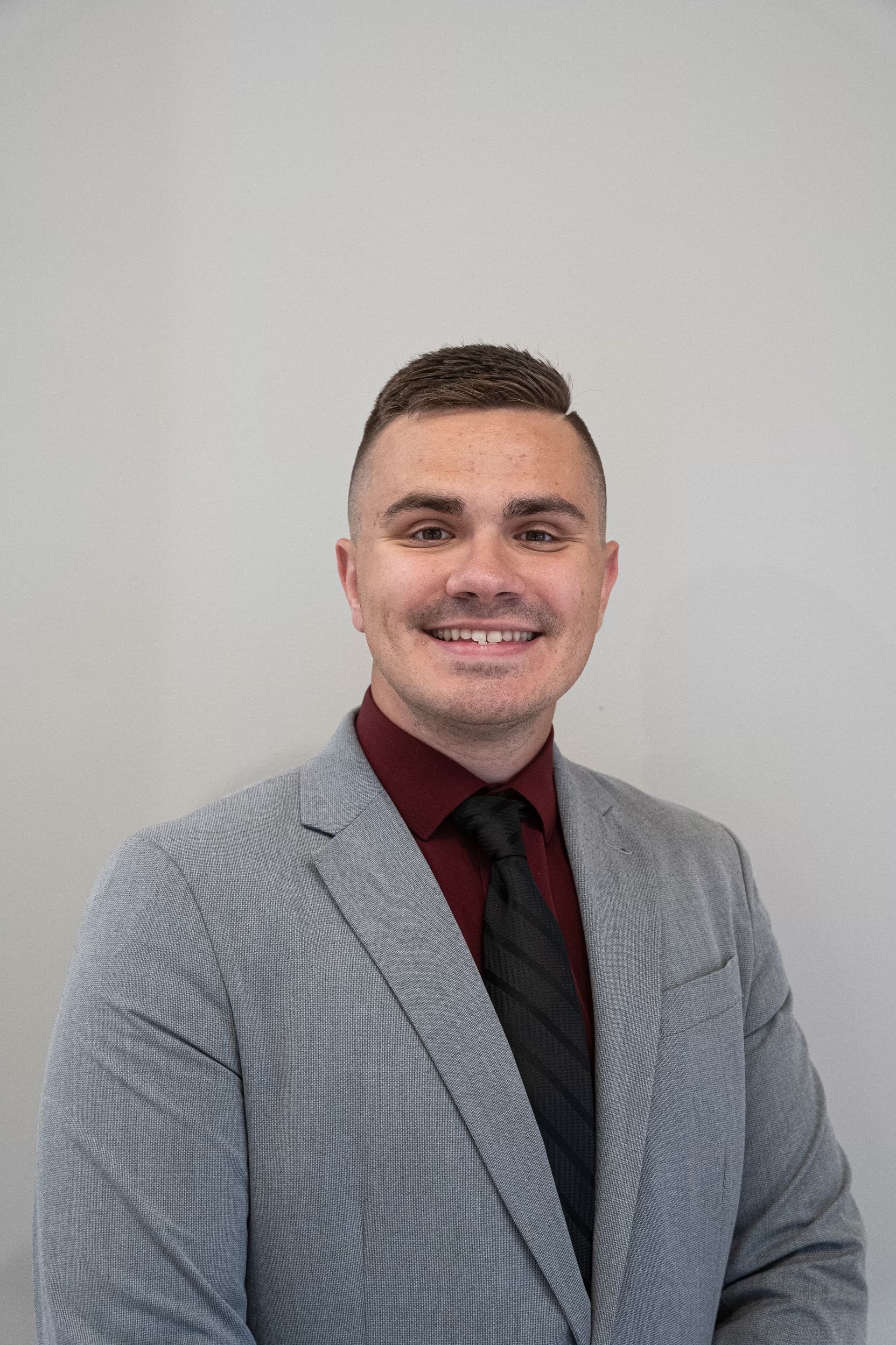 A man in a suit and tie is smiling for the camera.