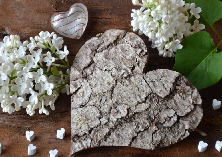 White lilac blossoms beside a rustic heart-shaped bark decor, cremation services Warner Robins, GA