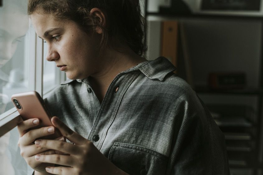 teen girl holding her phone, funeral homes Bonaire, GA