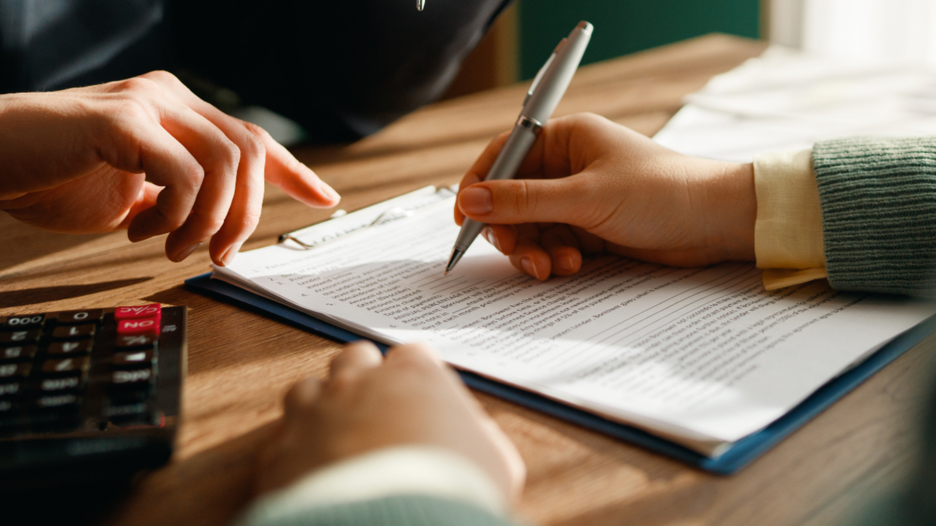 Real estate transaction paperwork being reviewed and signed with a transaction coordinator.