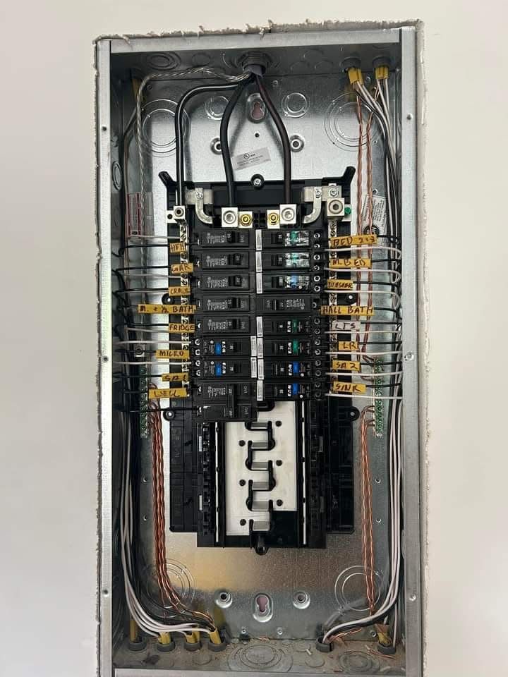 Open electrical panel with circuit breakers and wires inside.