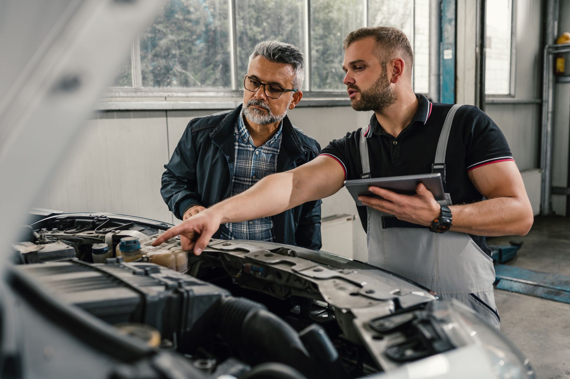 Mechanic showing engine to man