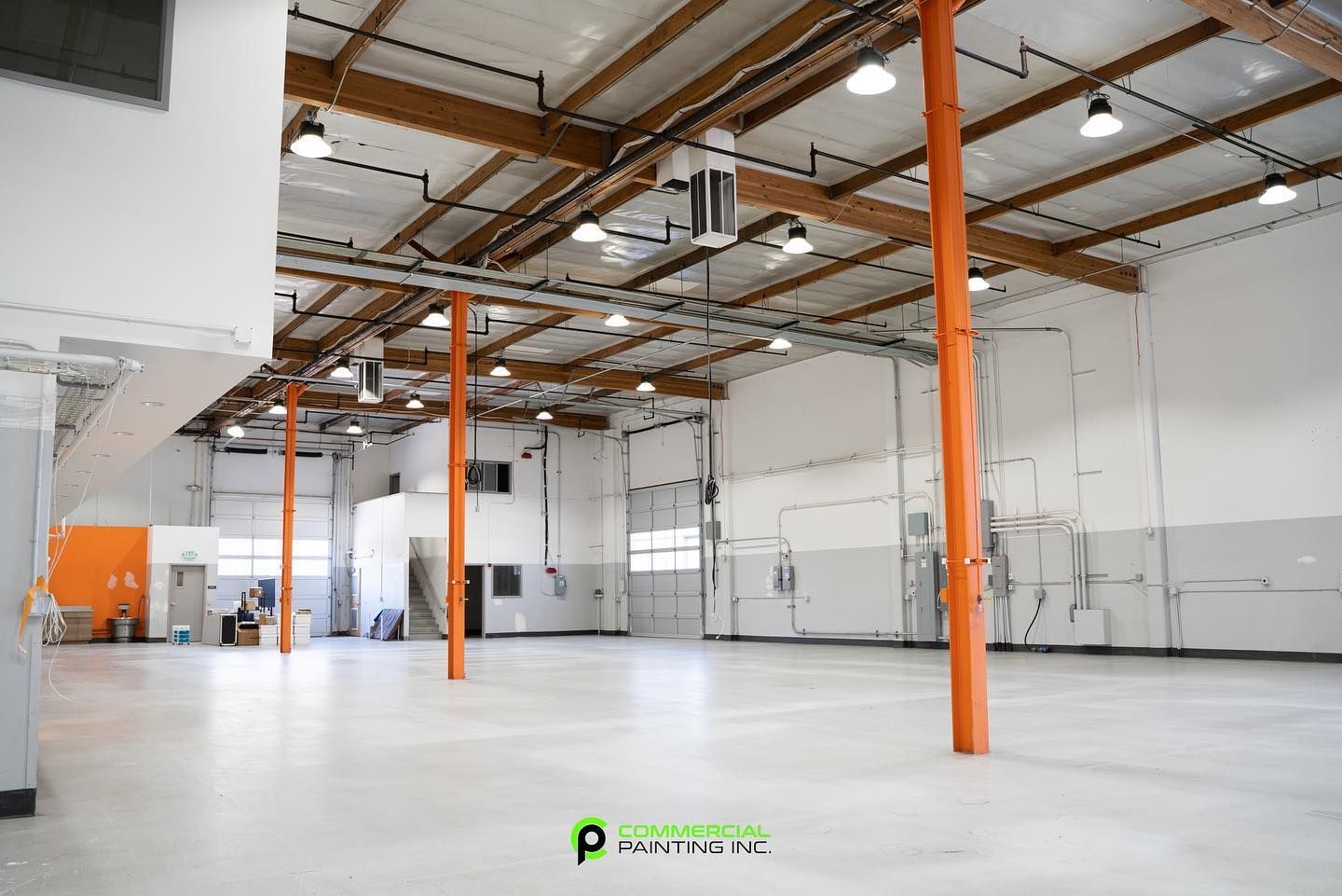 A large empty warehouse with a lot of lights on the ceiling.