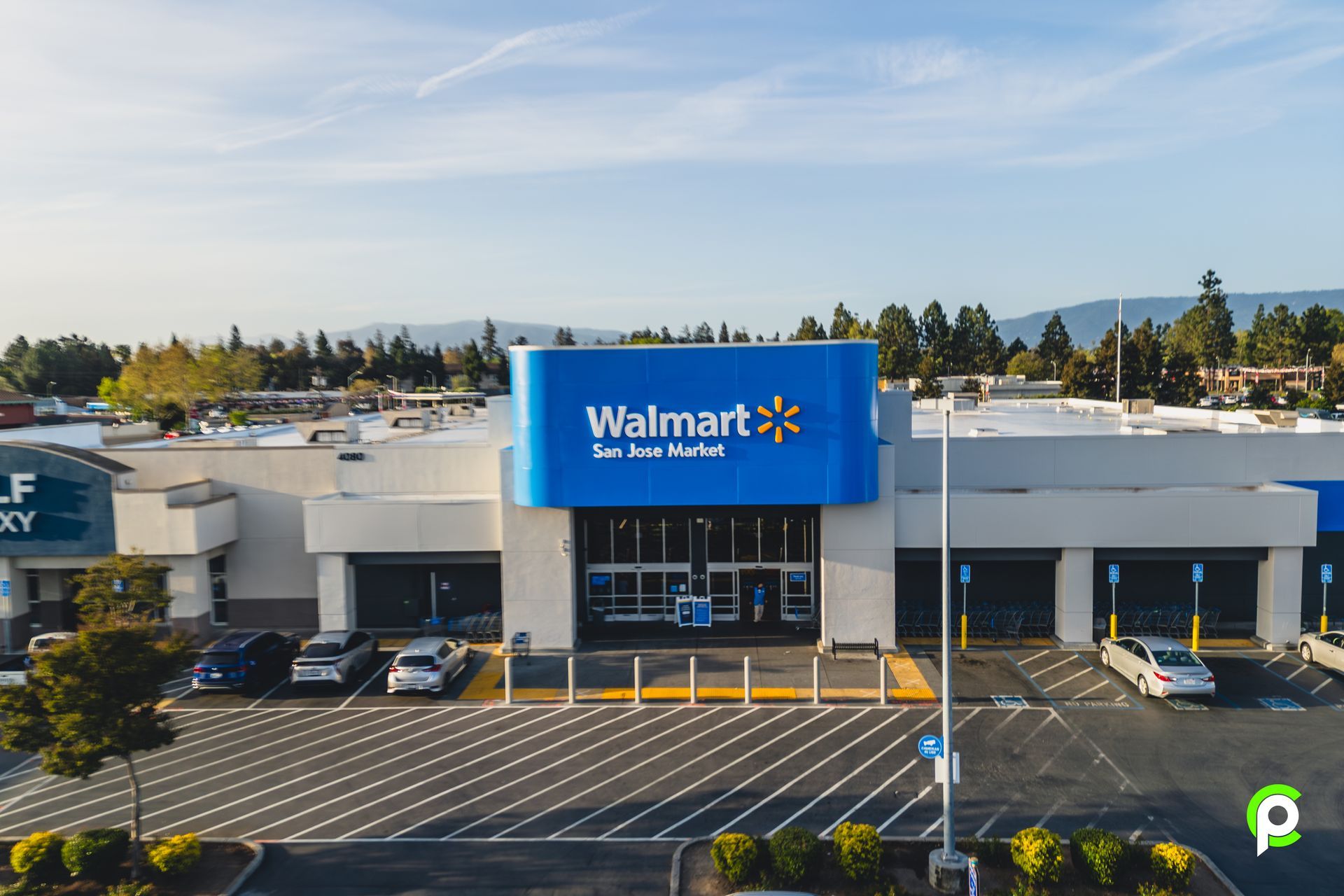 An aerial view of a walmart store with cars parked in front of it.