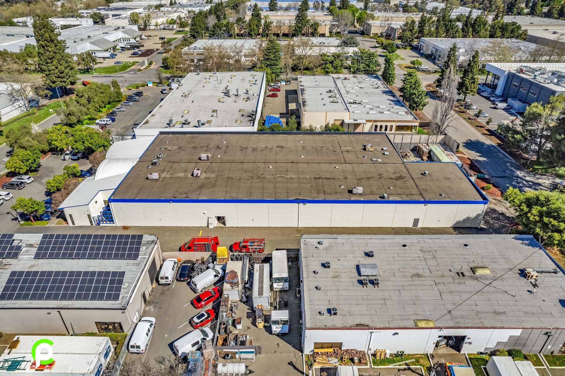 An aerial view of a large warehouse with a lot of trucks parked in front of it.