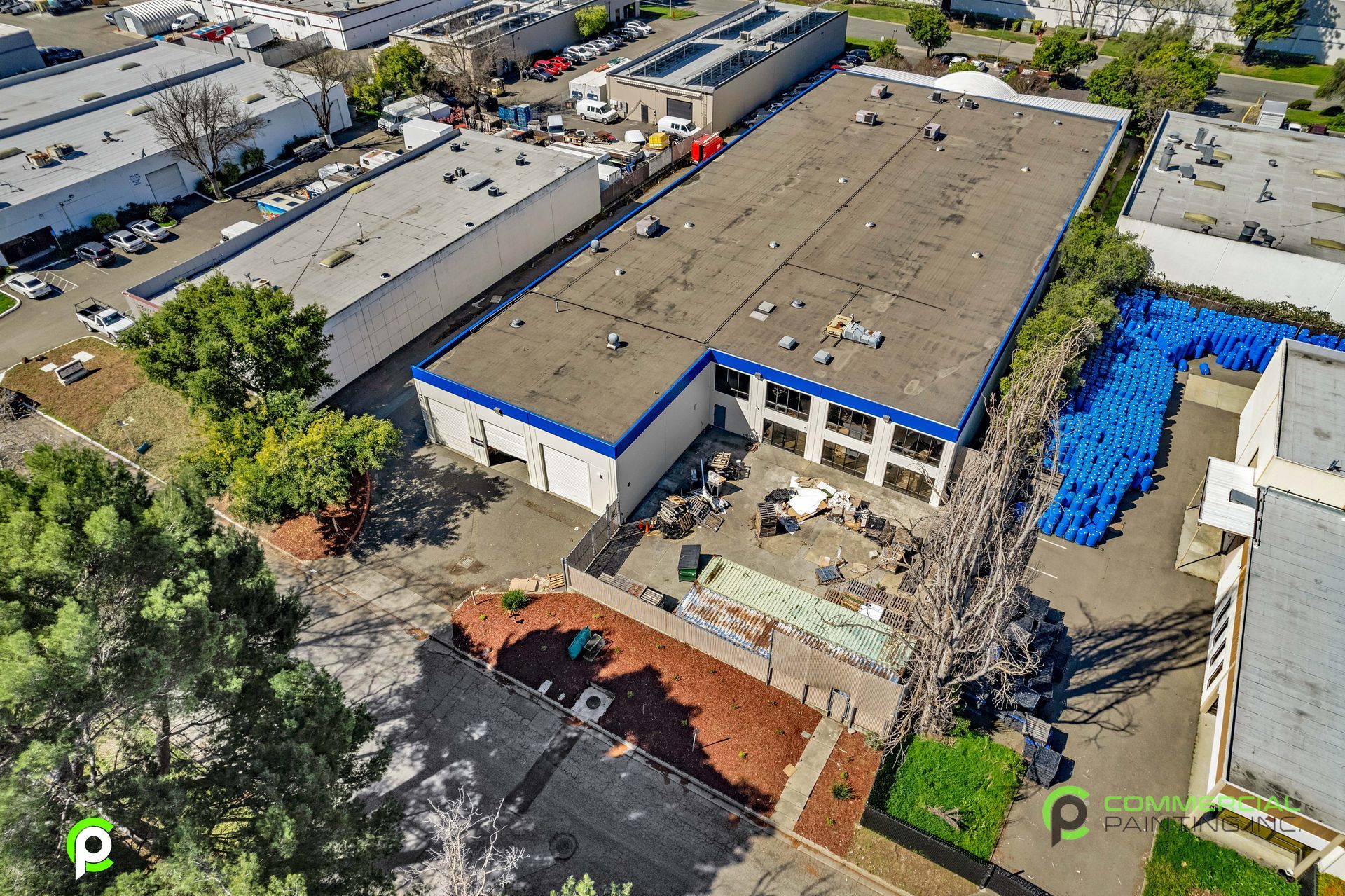 An aerial view of a large building with a blue roof