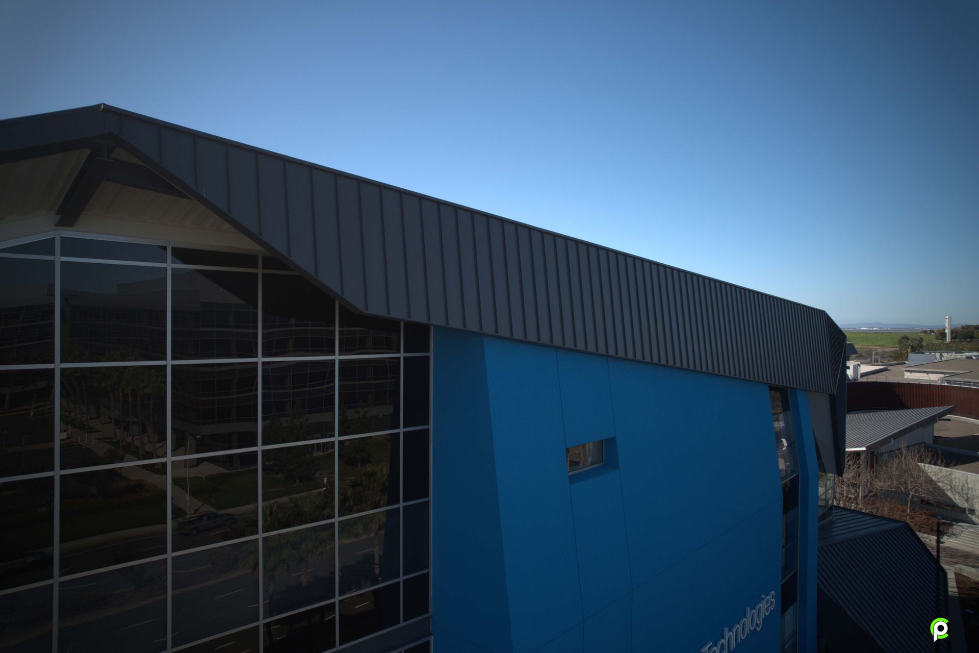 An aerial view of a large blue building with a lot of windows