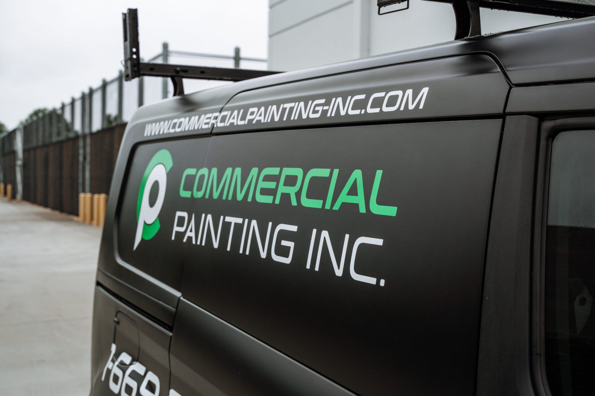 A black van with the words commercial painting inc. on the side