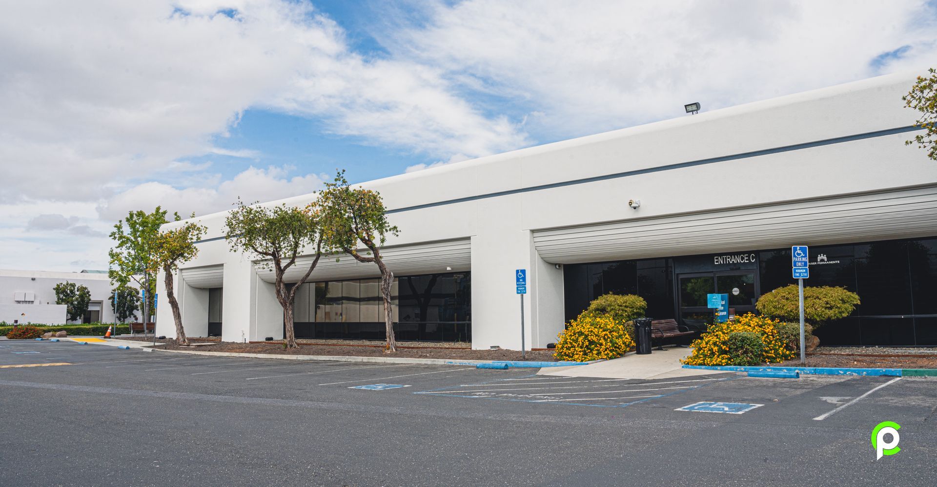 A large white building with a parking lot in front of it.