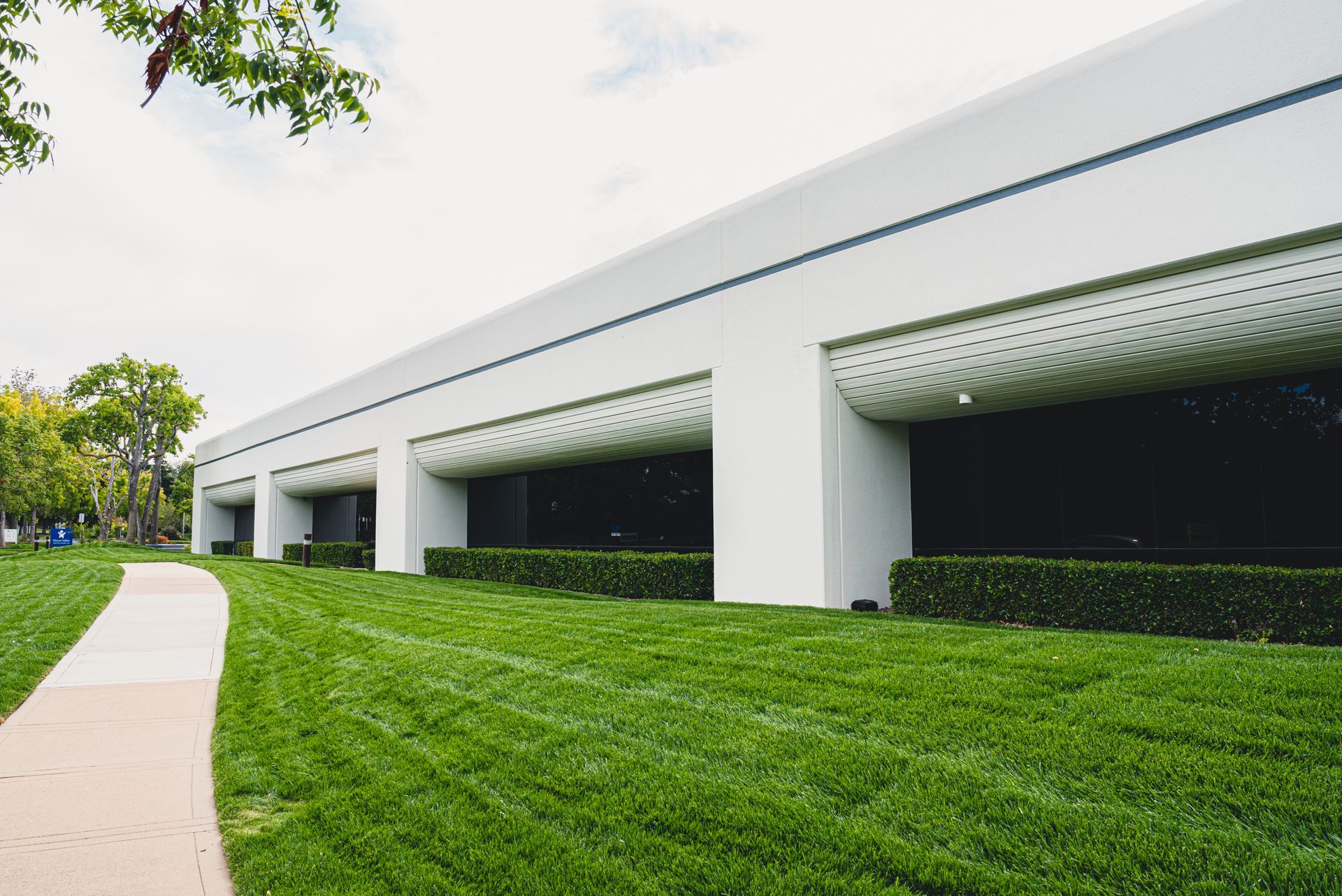 A large white building with a lush green lawn in front of it.