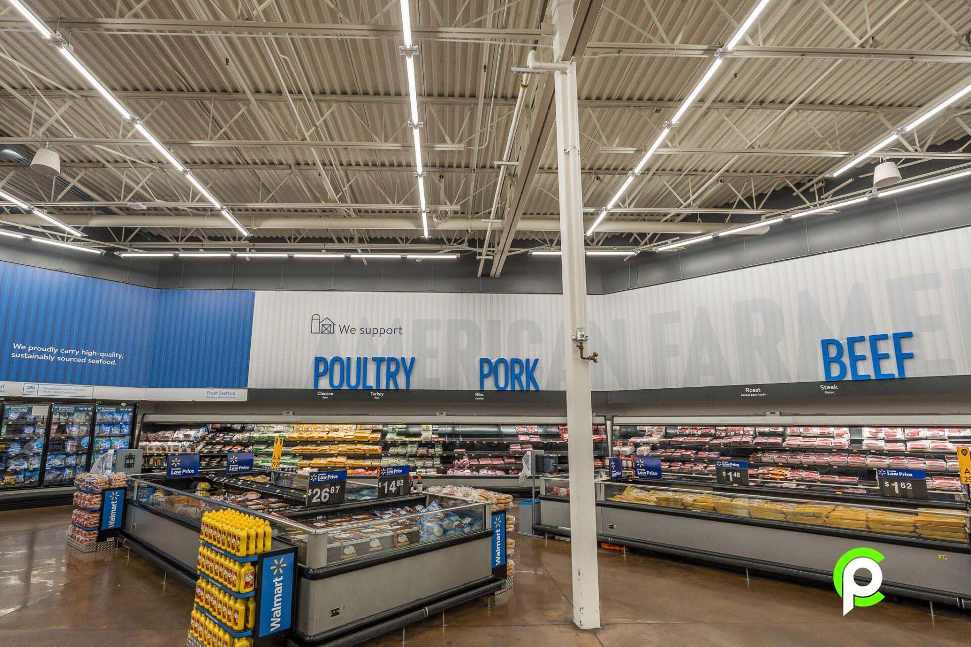 The inside of a grocery store with a sign that says poultry pork and beef.