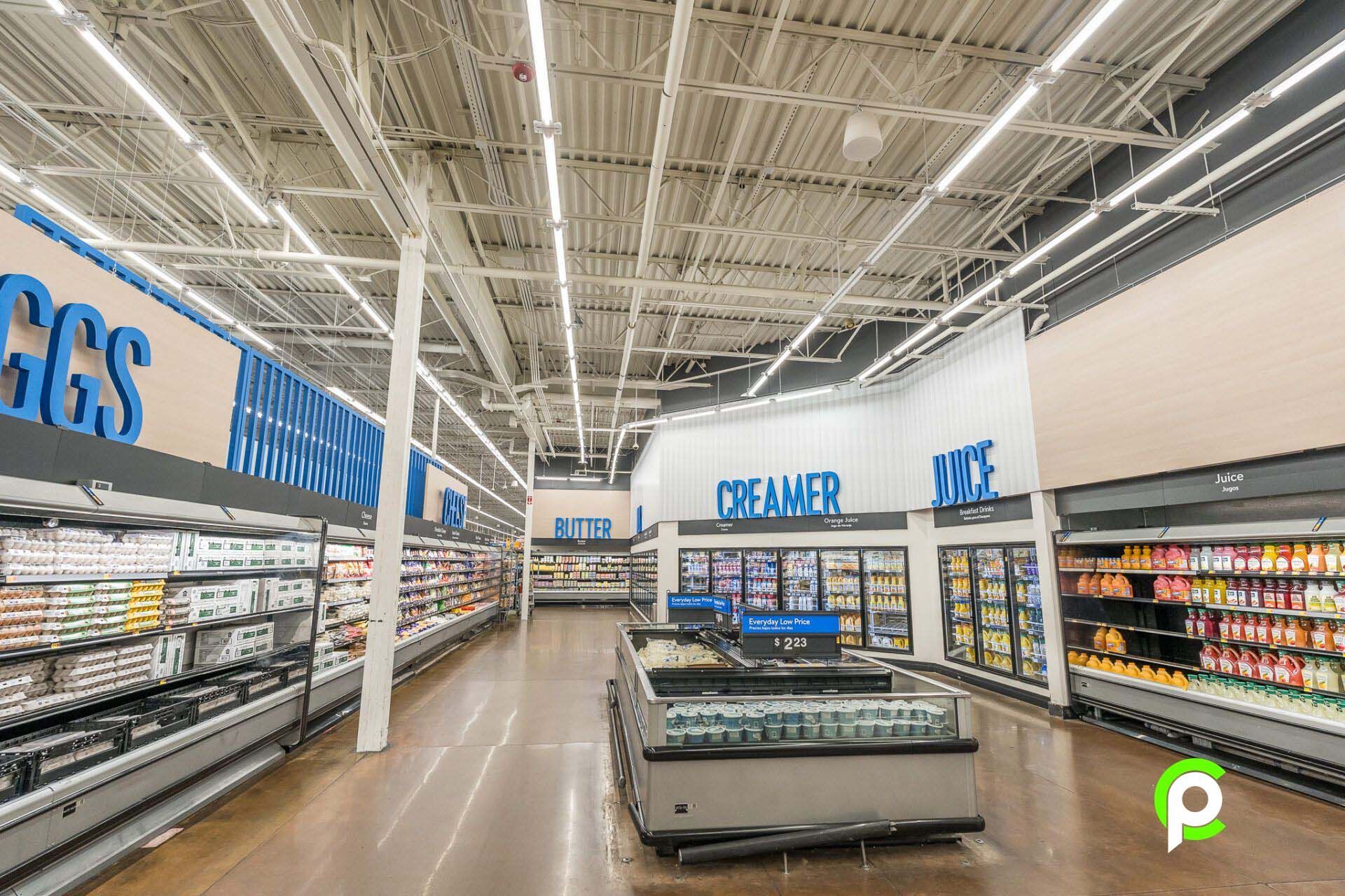 The inside of a grocery store with a lot of shelves and refrigerators.
