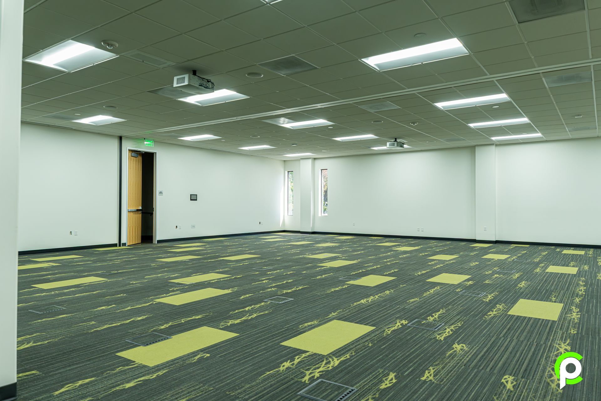 A large empty room with a projector on the ceiling.