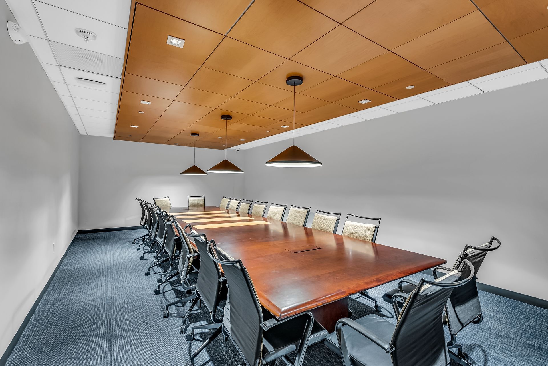 A large empty office with a lot of windows and desks and chairs.