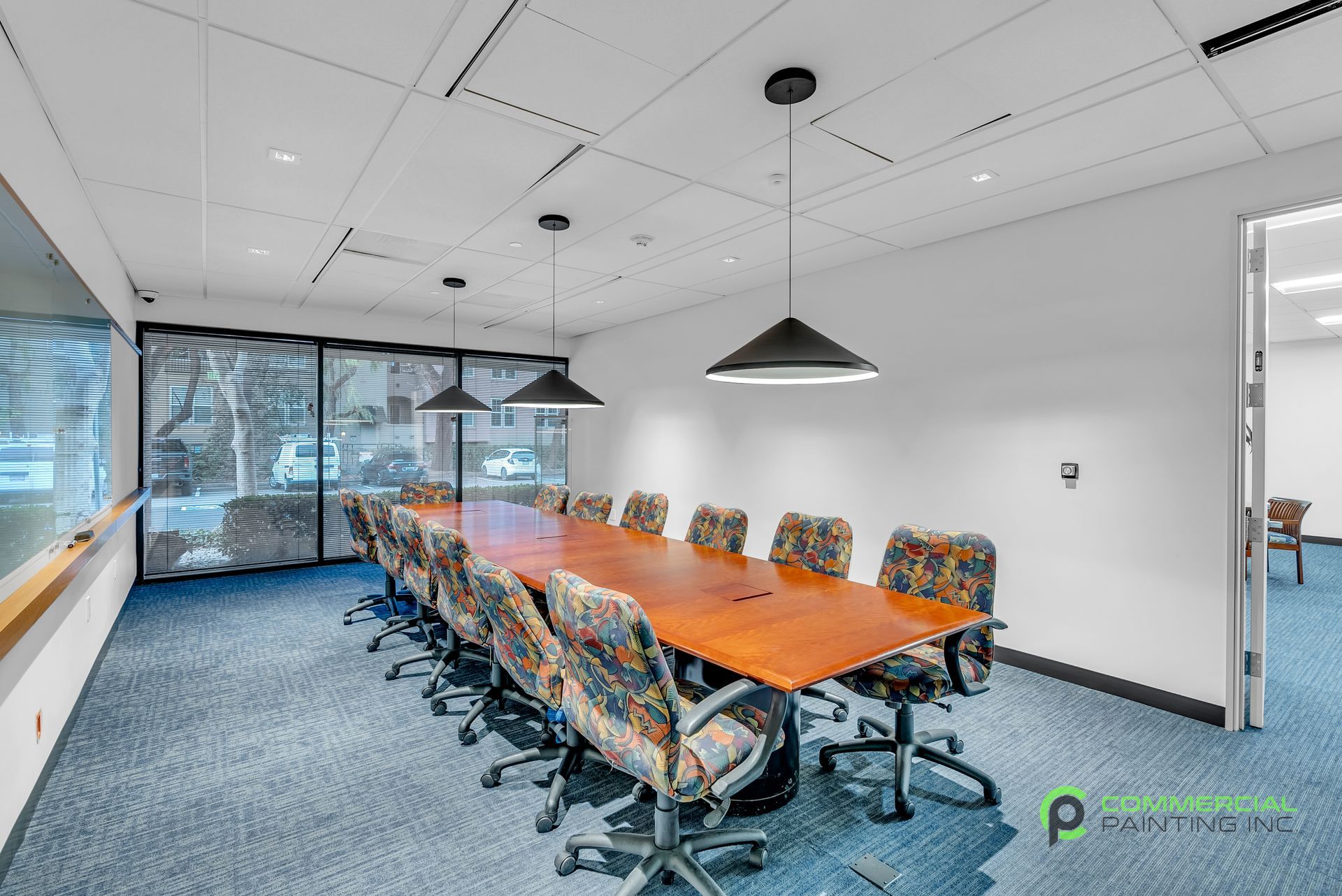 A conference room with a long wooden table and chairs.