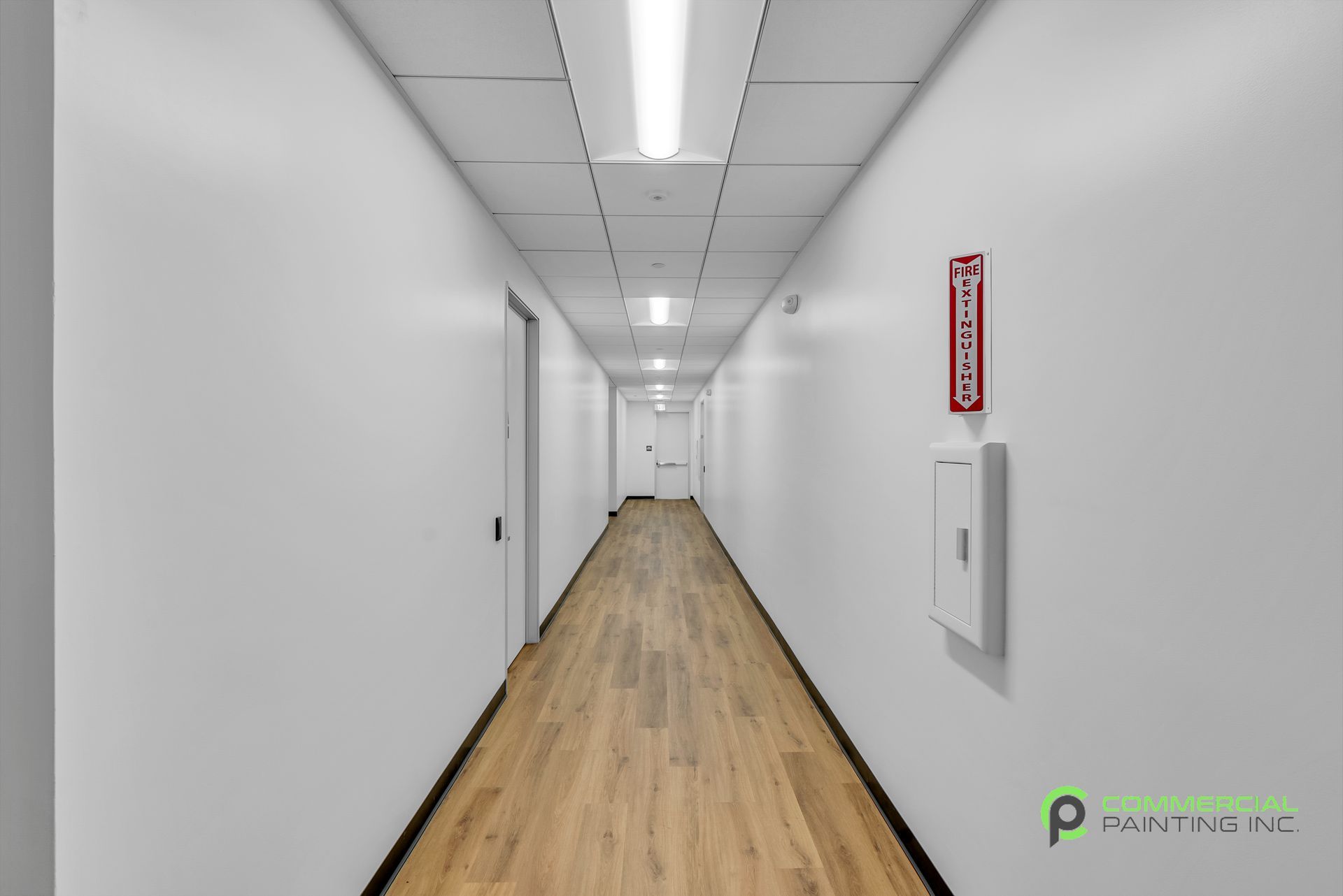 A long hallway with wooden floors and white walls