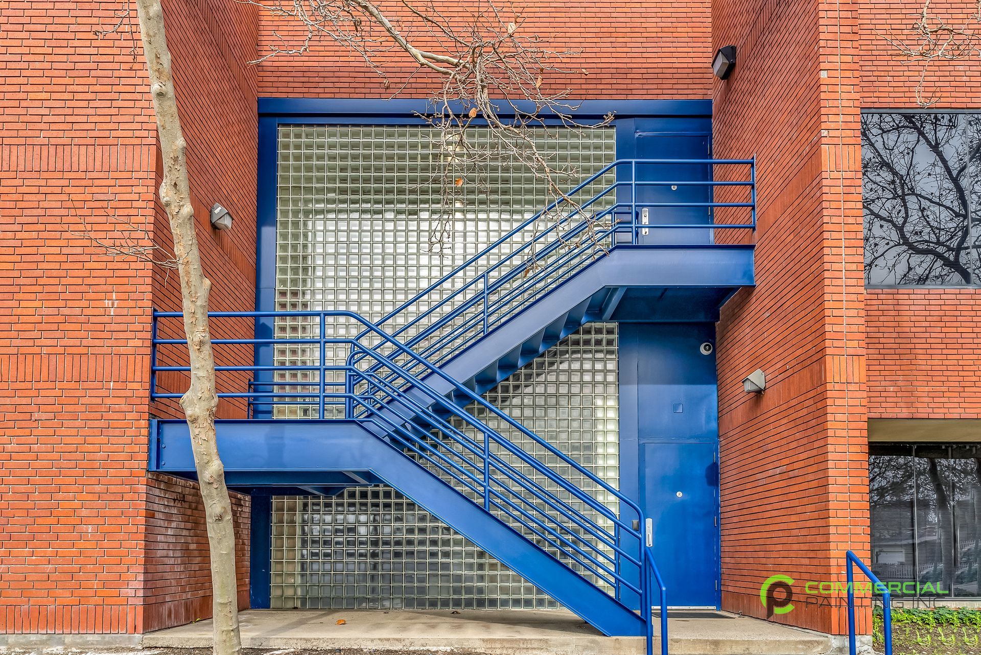 A blue fire escape on the side of a brick building