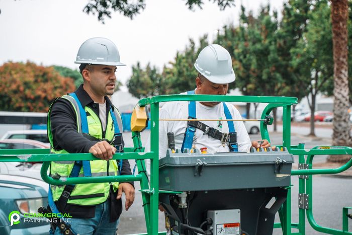 Two construction workers are standing next to each other in a parking lot.