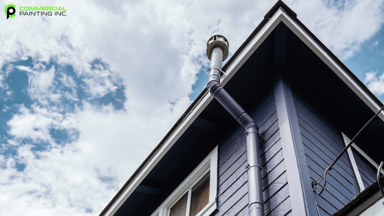 A blue house with a chimney on the roof.
