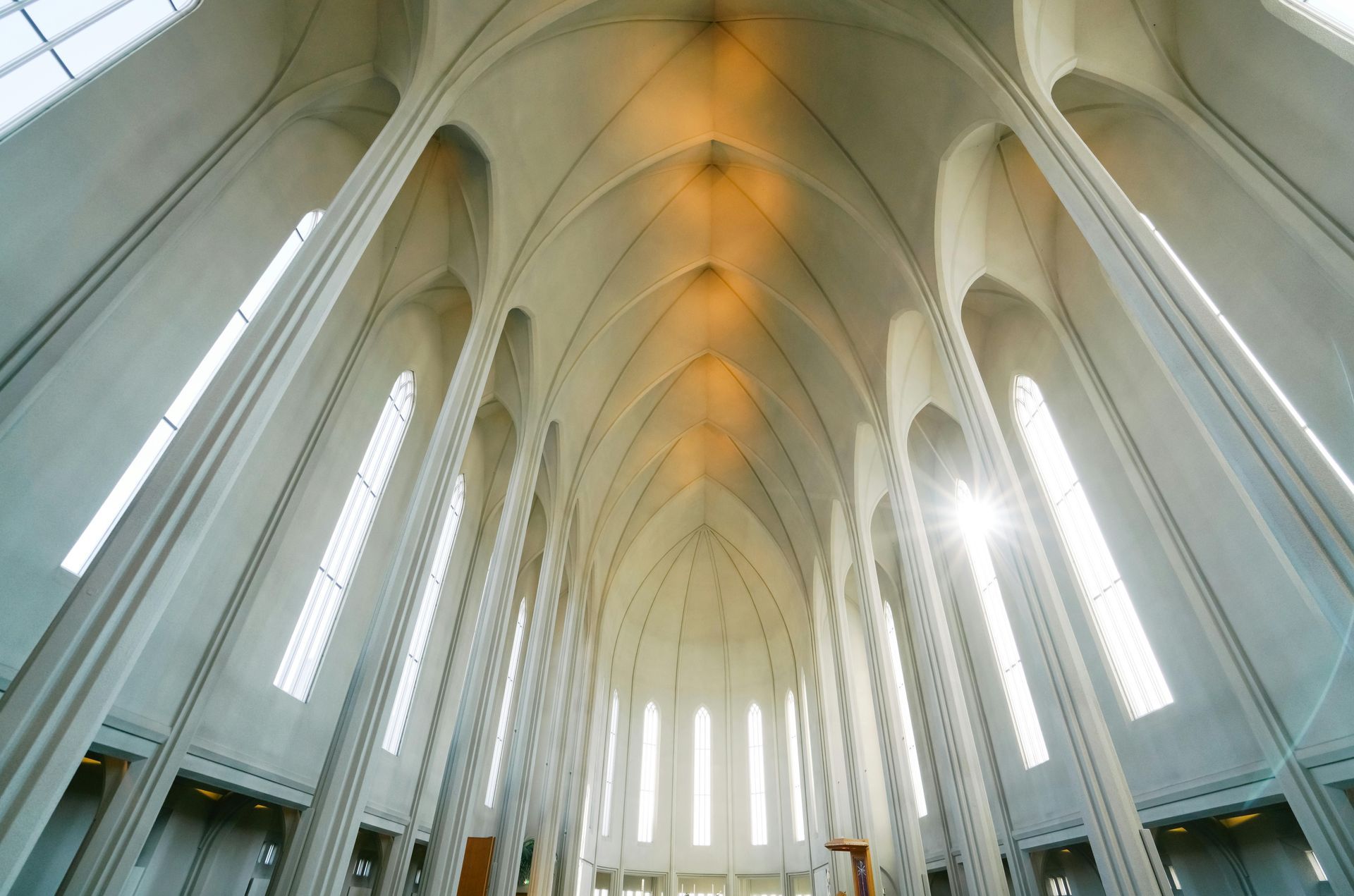 A church with rows of wooden benches and a red carpet.