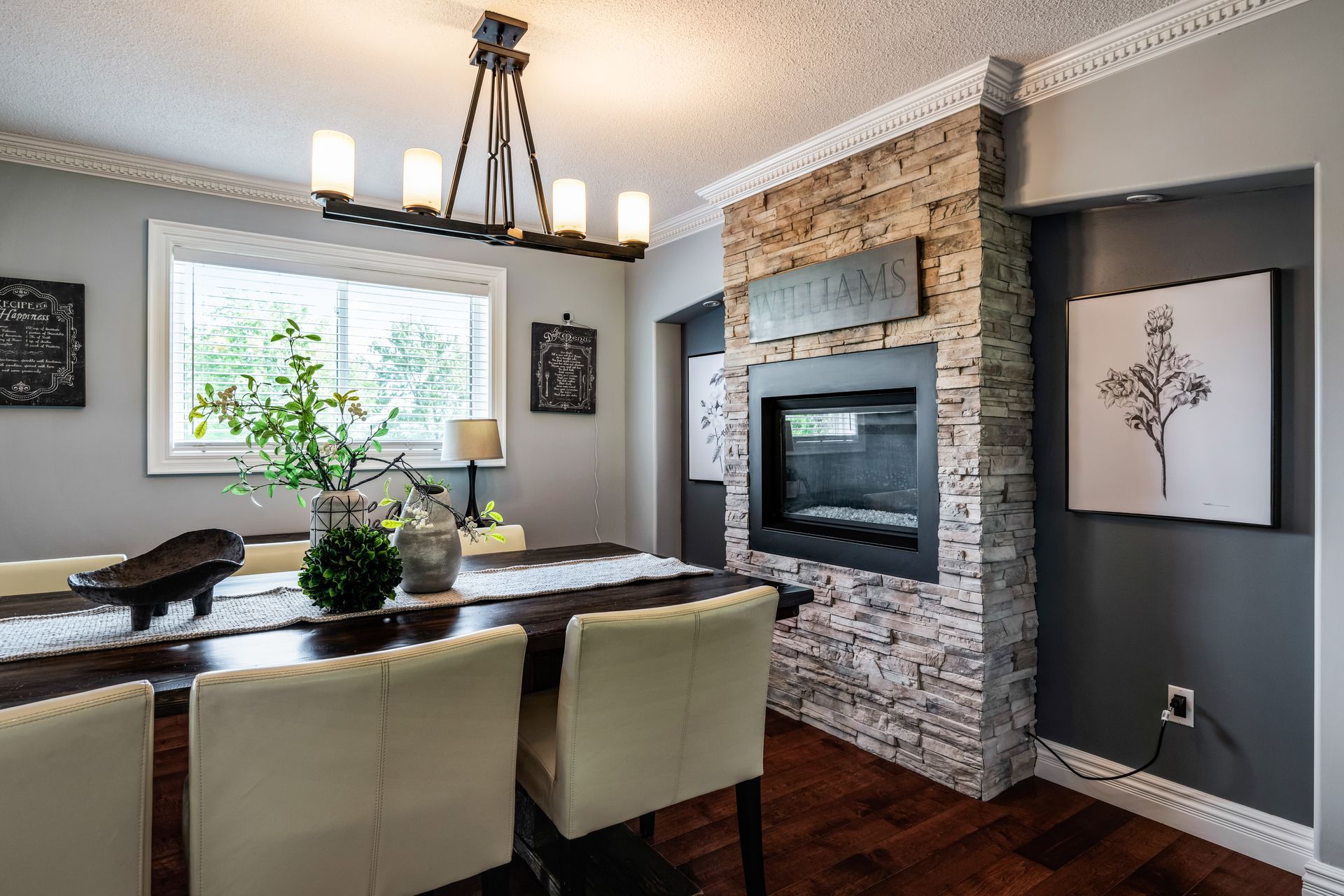 A dining room with a table and chairs and a fireplace.