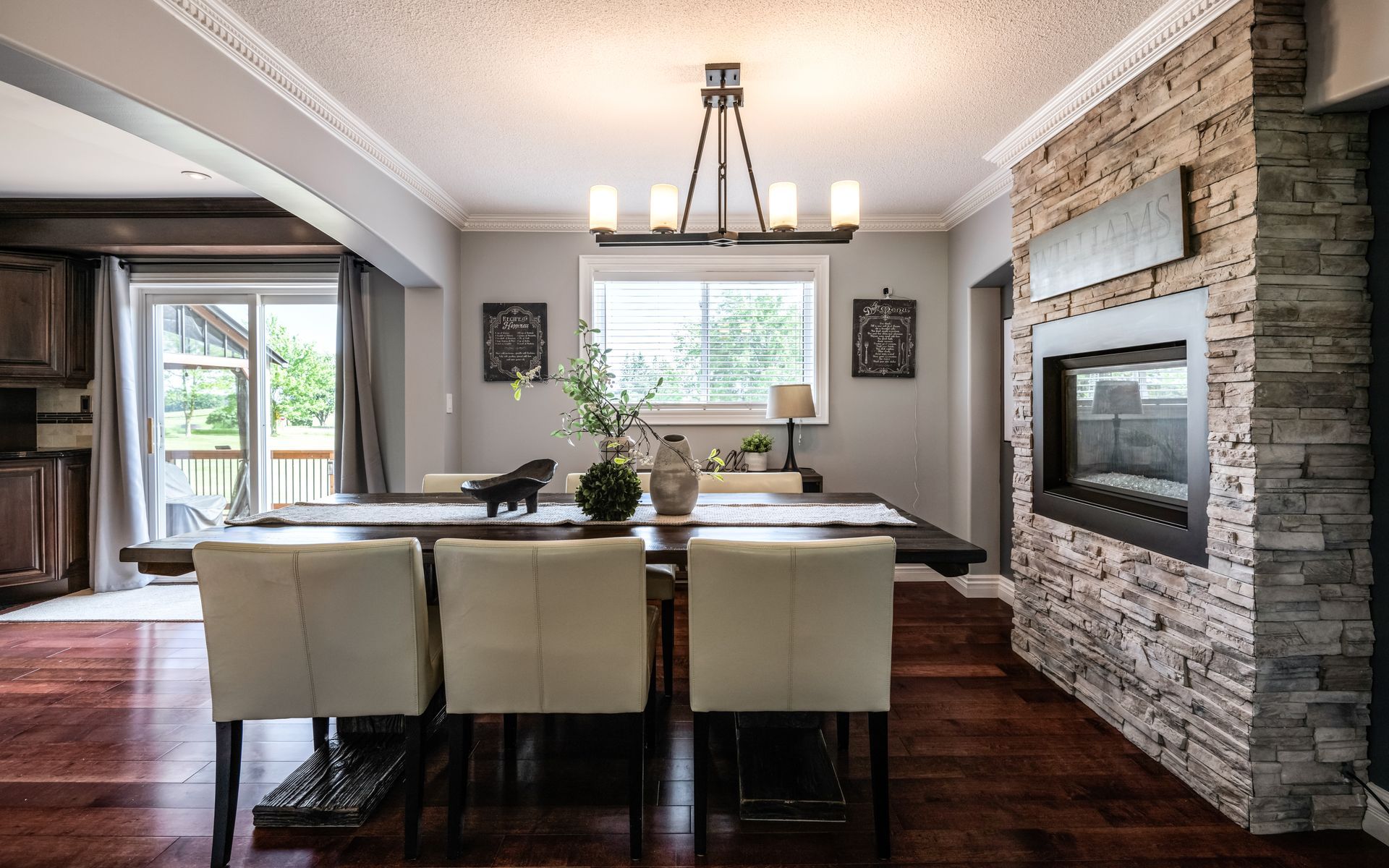 A dining room with a table and chairs and a fireplace.