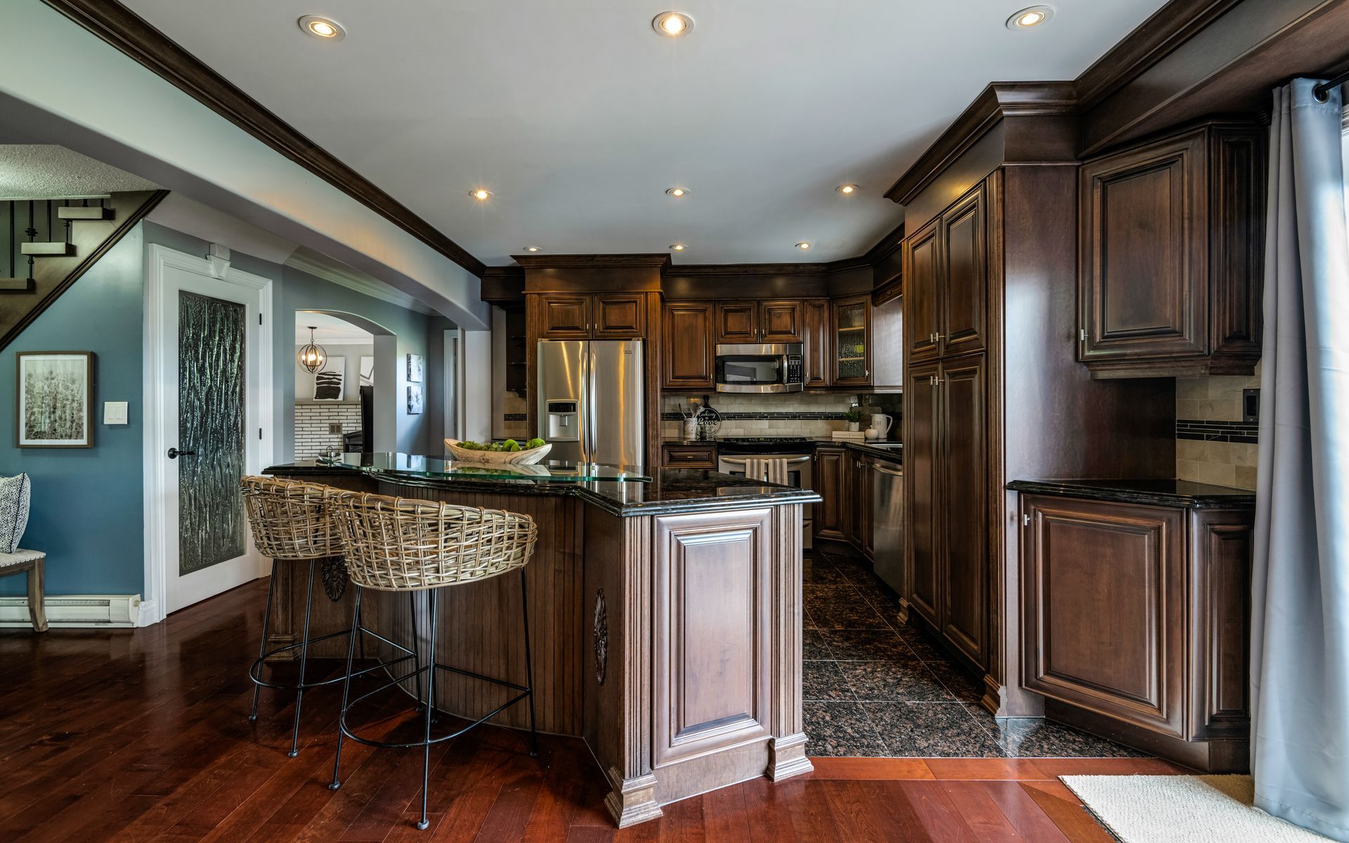 A kitchen with wooden cabinets , stainless steel appliances , and a large island.