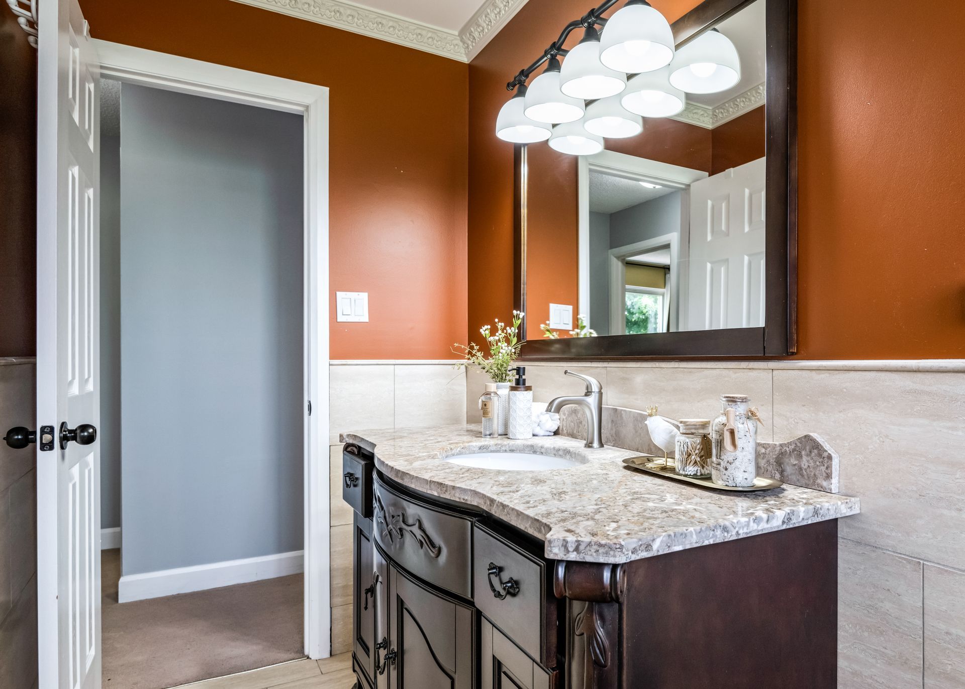 A bathroom with a sink , mirror and cabinets.