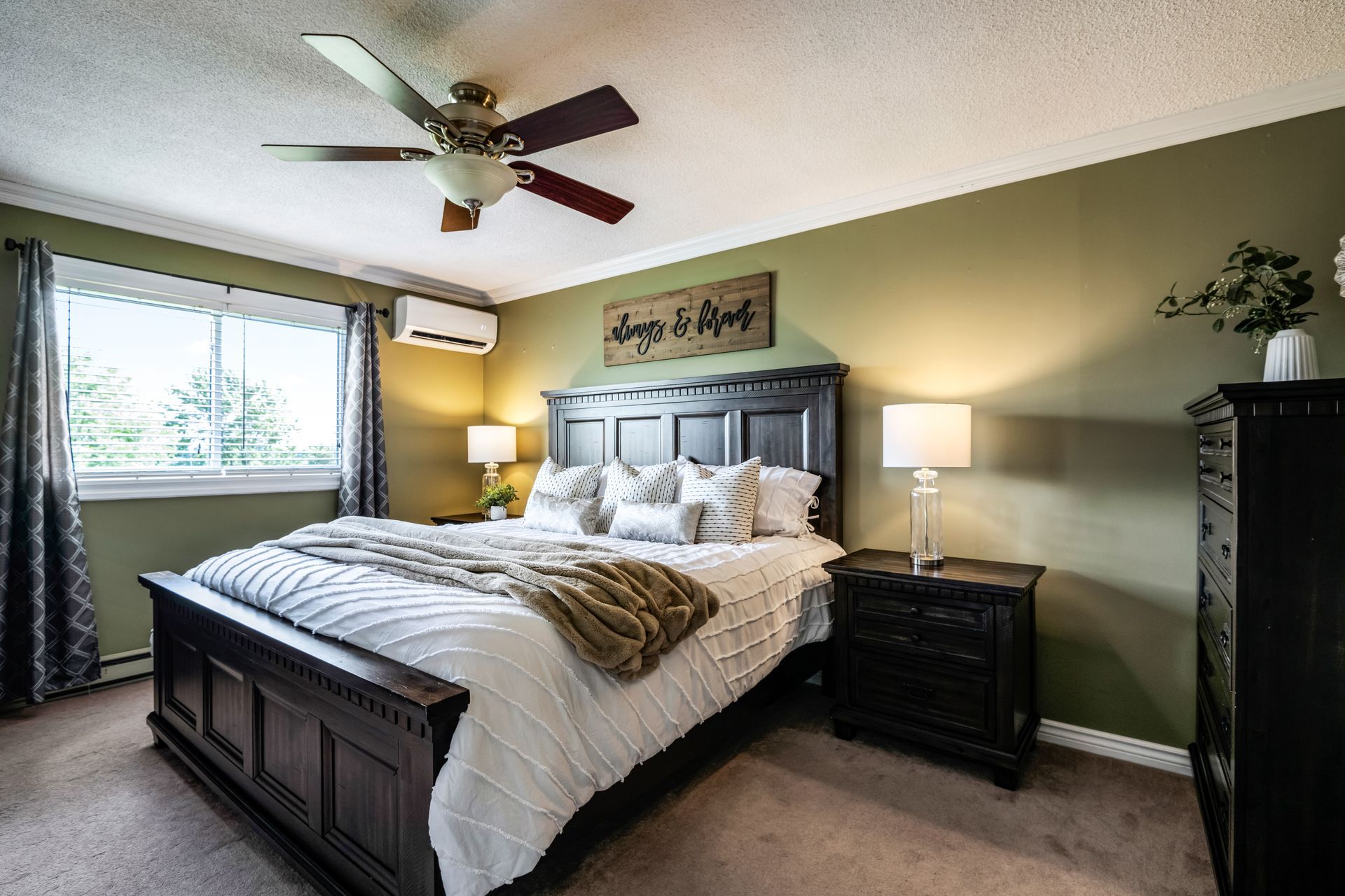 A bedroom with a king size bed and a ceiling fan.