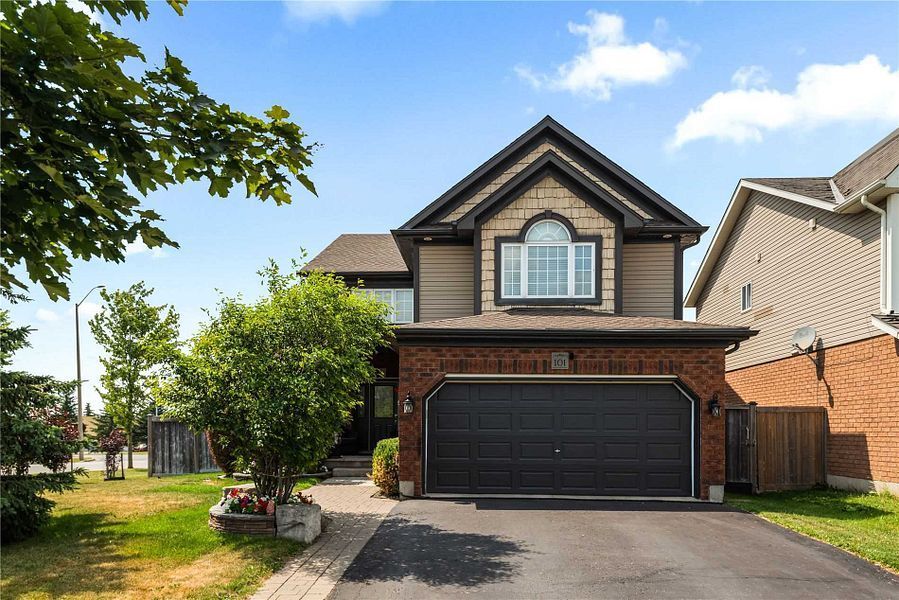 A large house with a black garage door is for sale