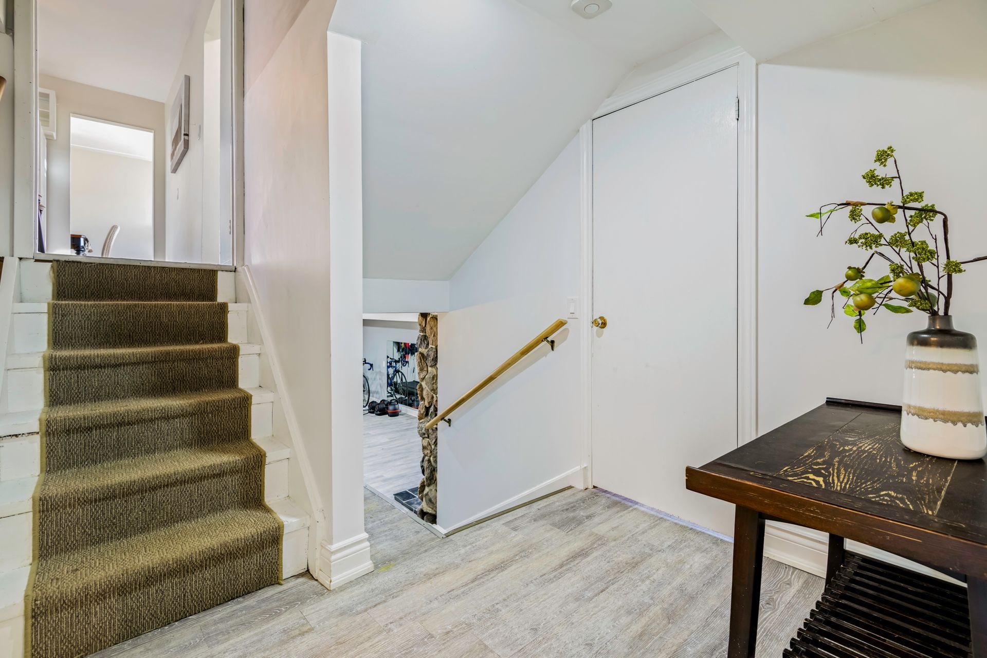 A hallway with stairs leading up to the second floor of a house.