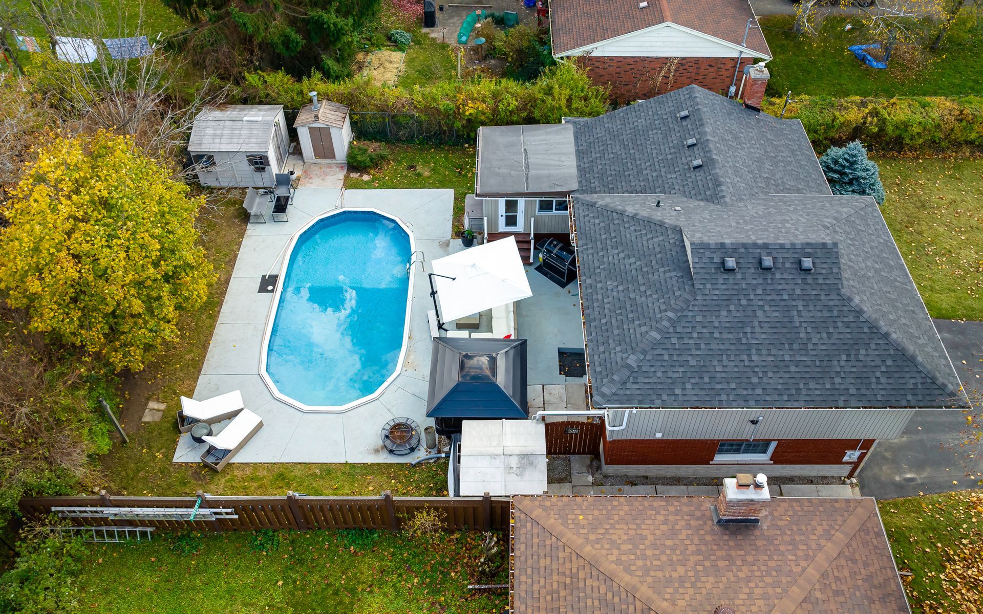 An aerial view of a house with a large swimming pool in the backyard.