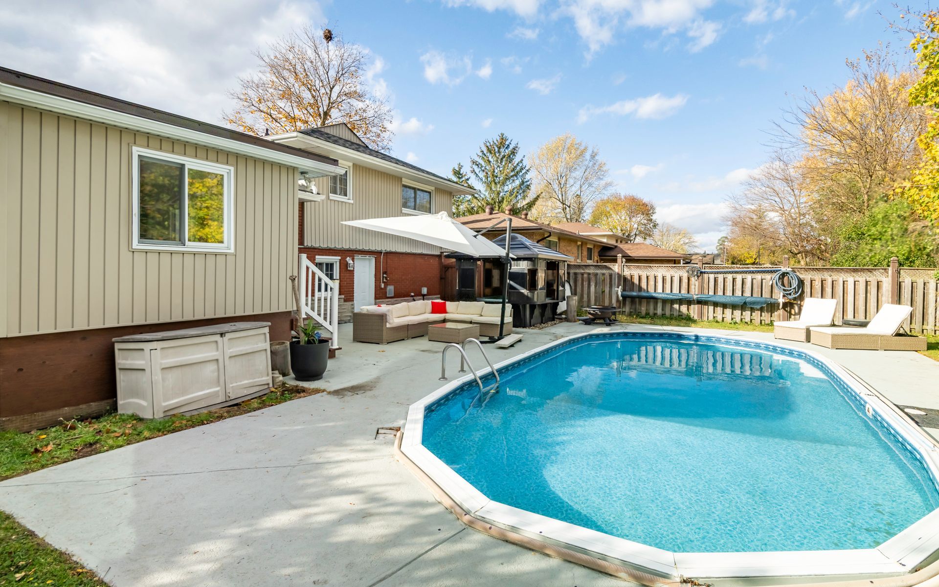A large swimming pool is in the backyard of a house.