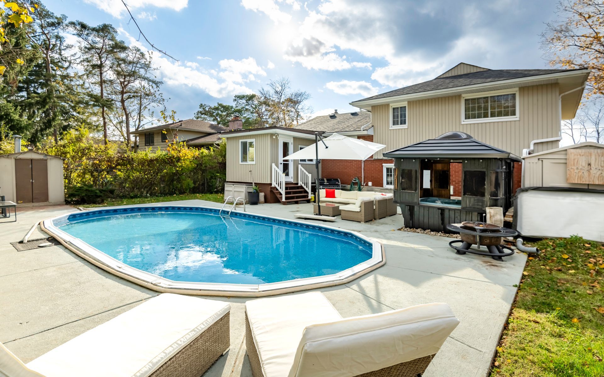 A large swimming pool is in the backyard of a house.