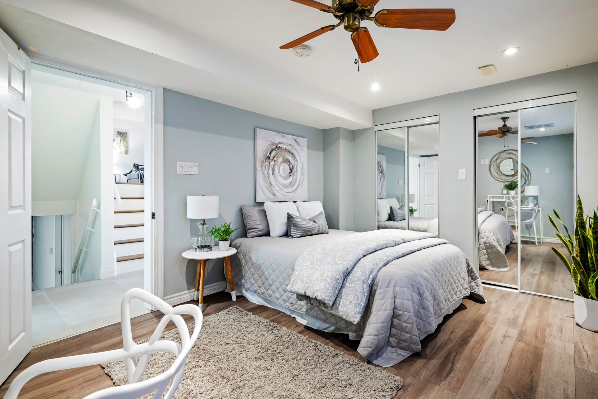 A bedroom with a ceiling fan and a large bed.