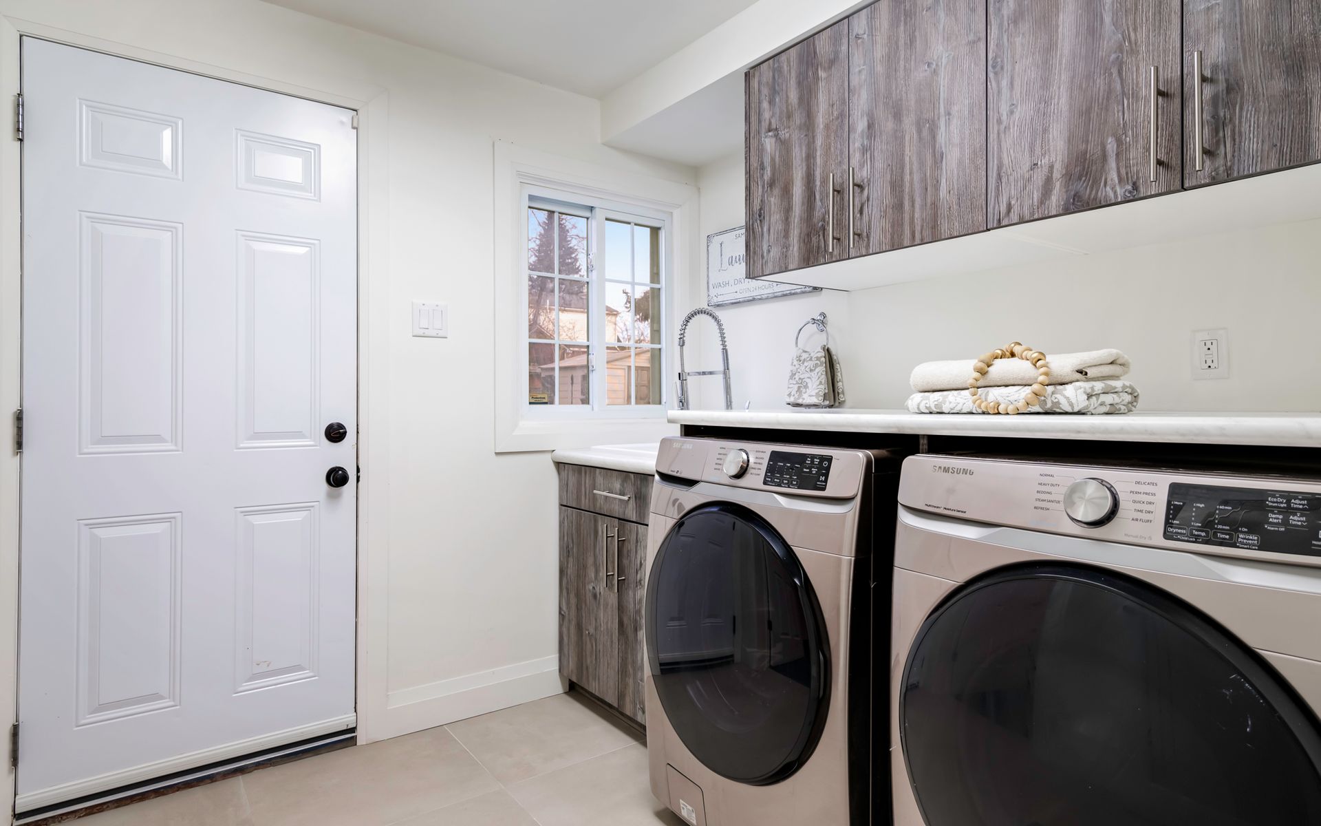 A laundry room with a washer and dryer and a door.
